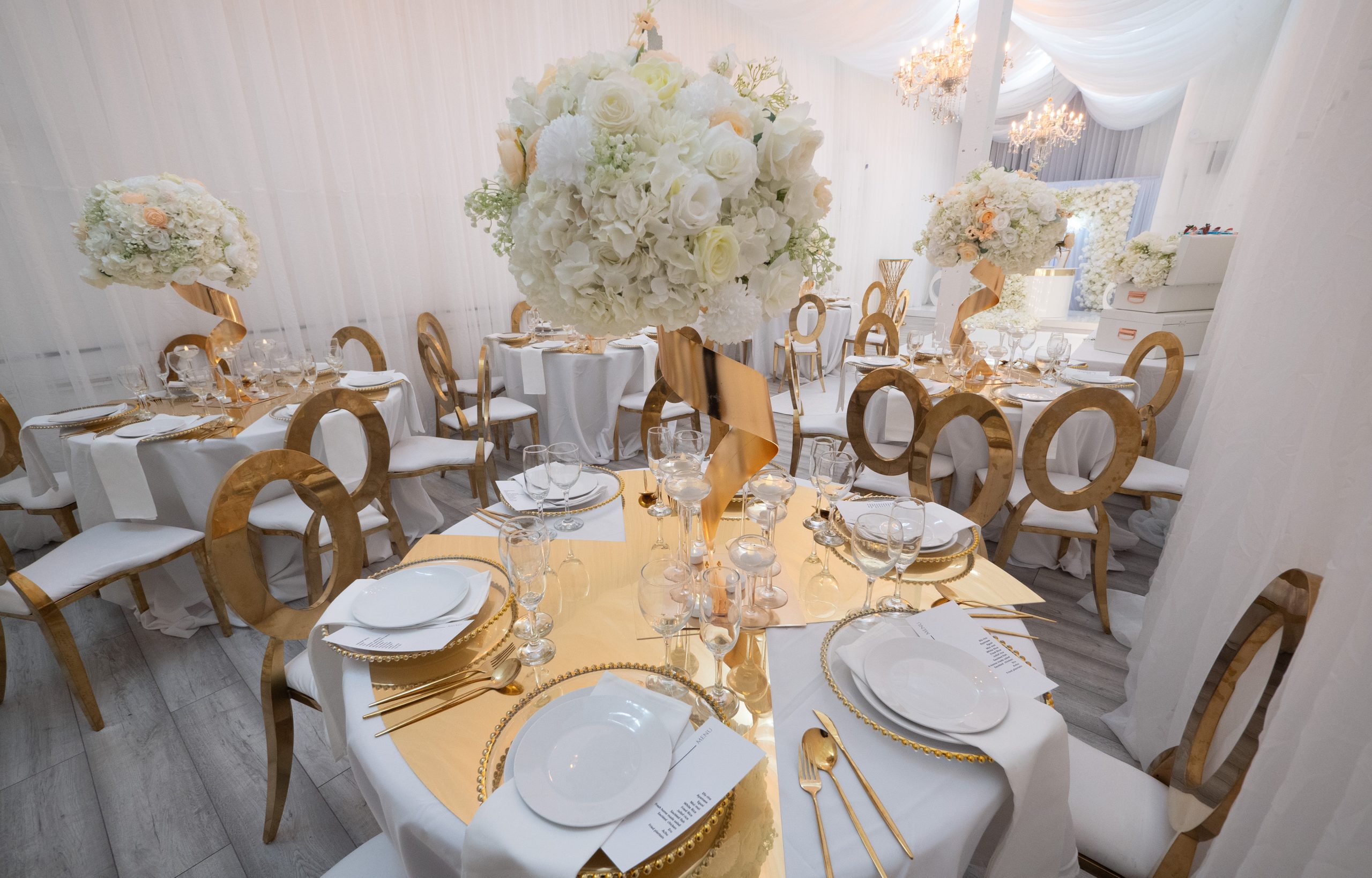 Elegant event room with round tables and floral centerpieces for weddings and corporate events.