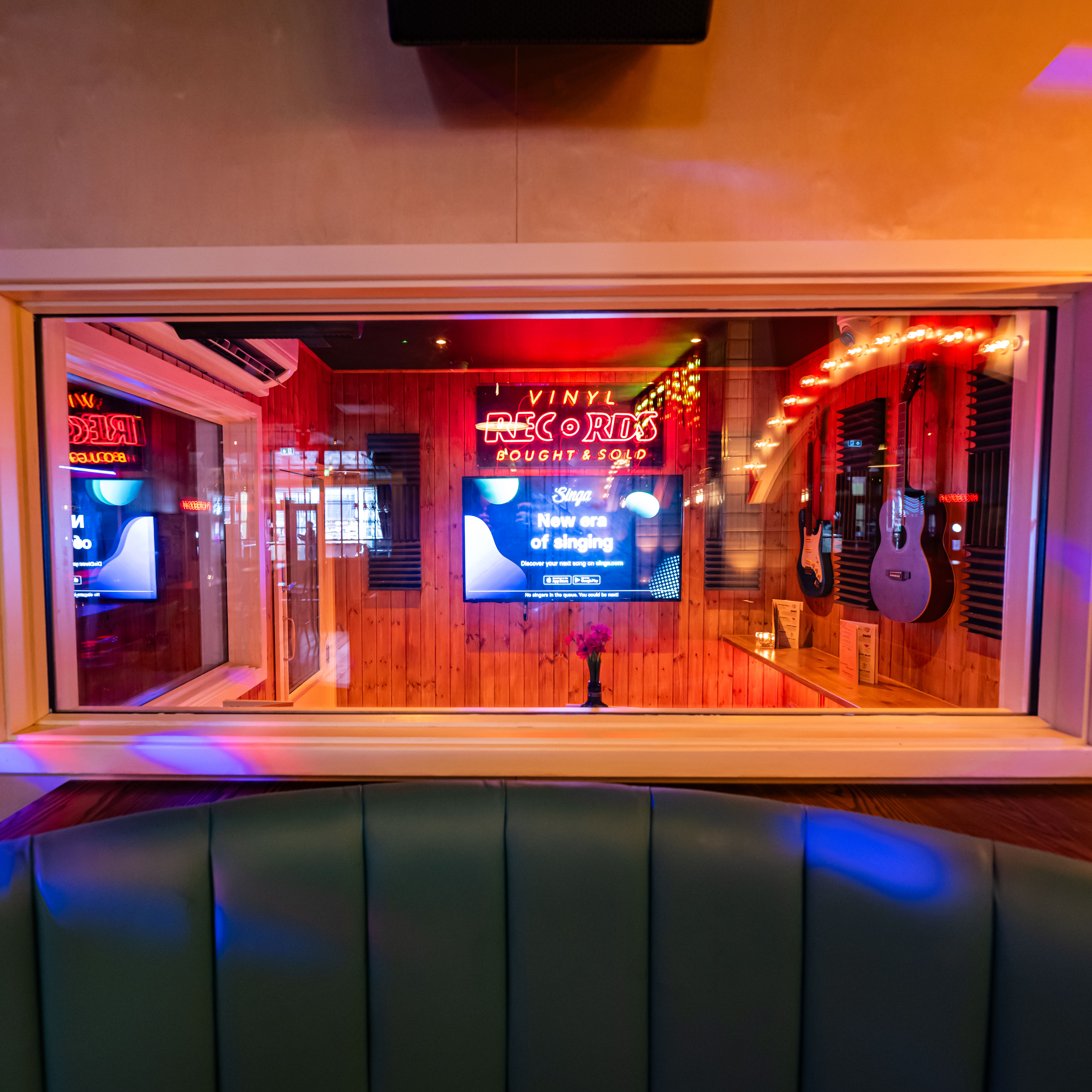 Vibrant karaoke room with neon decor, perfect for events and live performances.