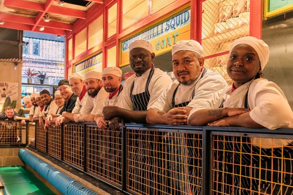 Diverse chefs in vibrant Turtle Bay Manchester kitchen, ideal for interactive dining events.