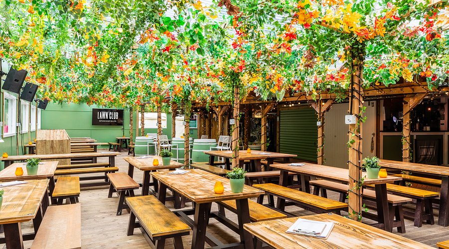 Vibrant cocktail bar with lush greenery, ideal for outdoor events and gatherings.