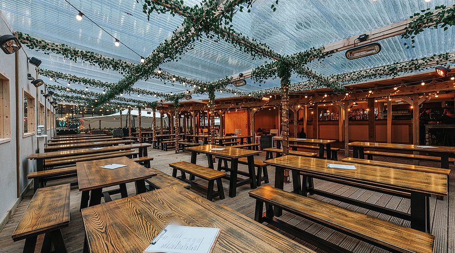 Outdoor cocktail bar with rustic tables, ideal for casual gatherings and events.