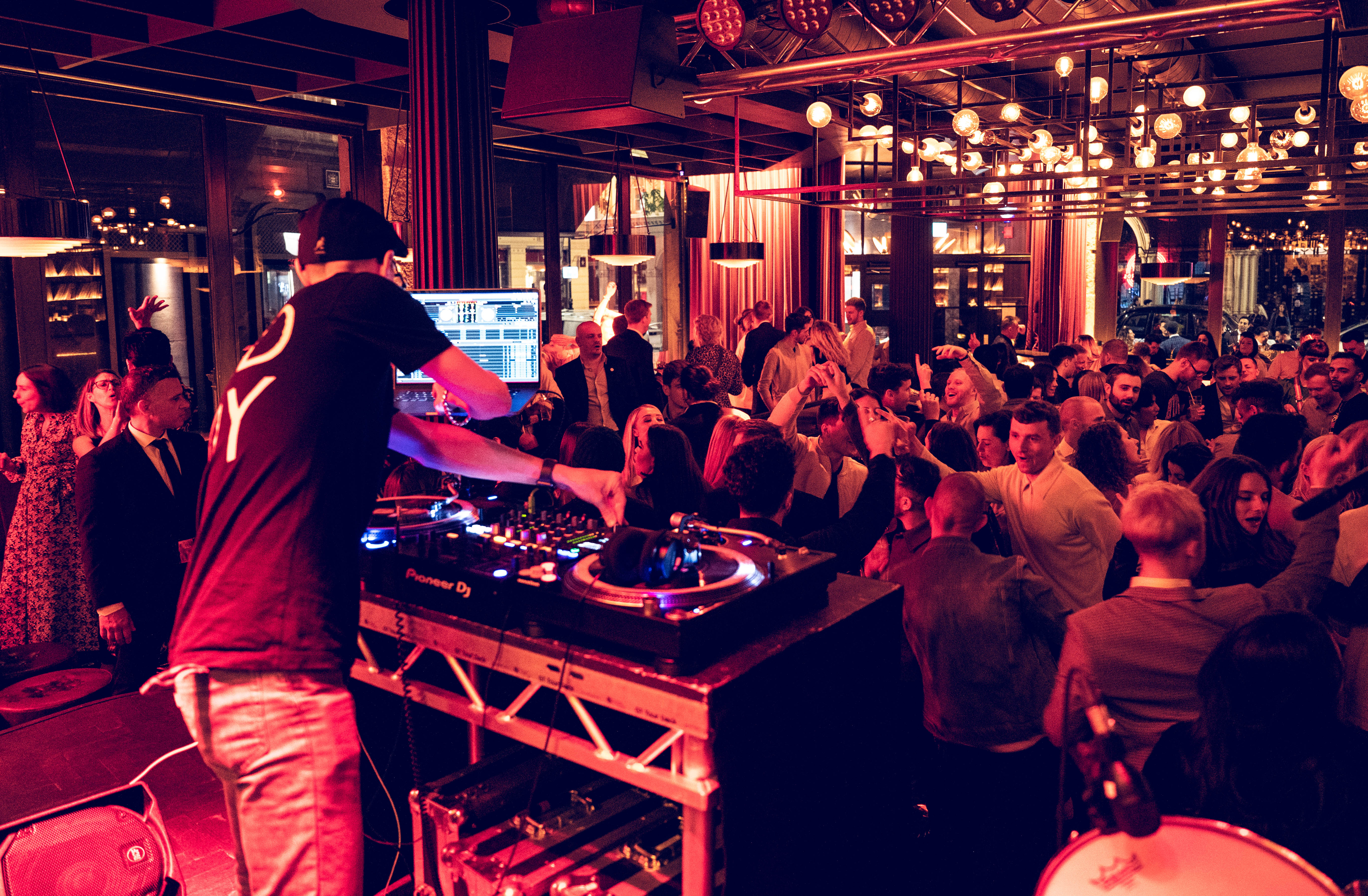 DJ energizing a lively crowd at Old Street Records for a corporate event or upscale party.