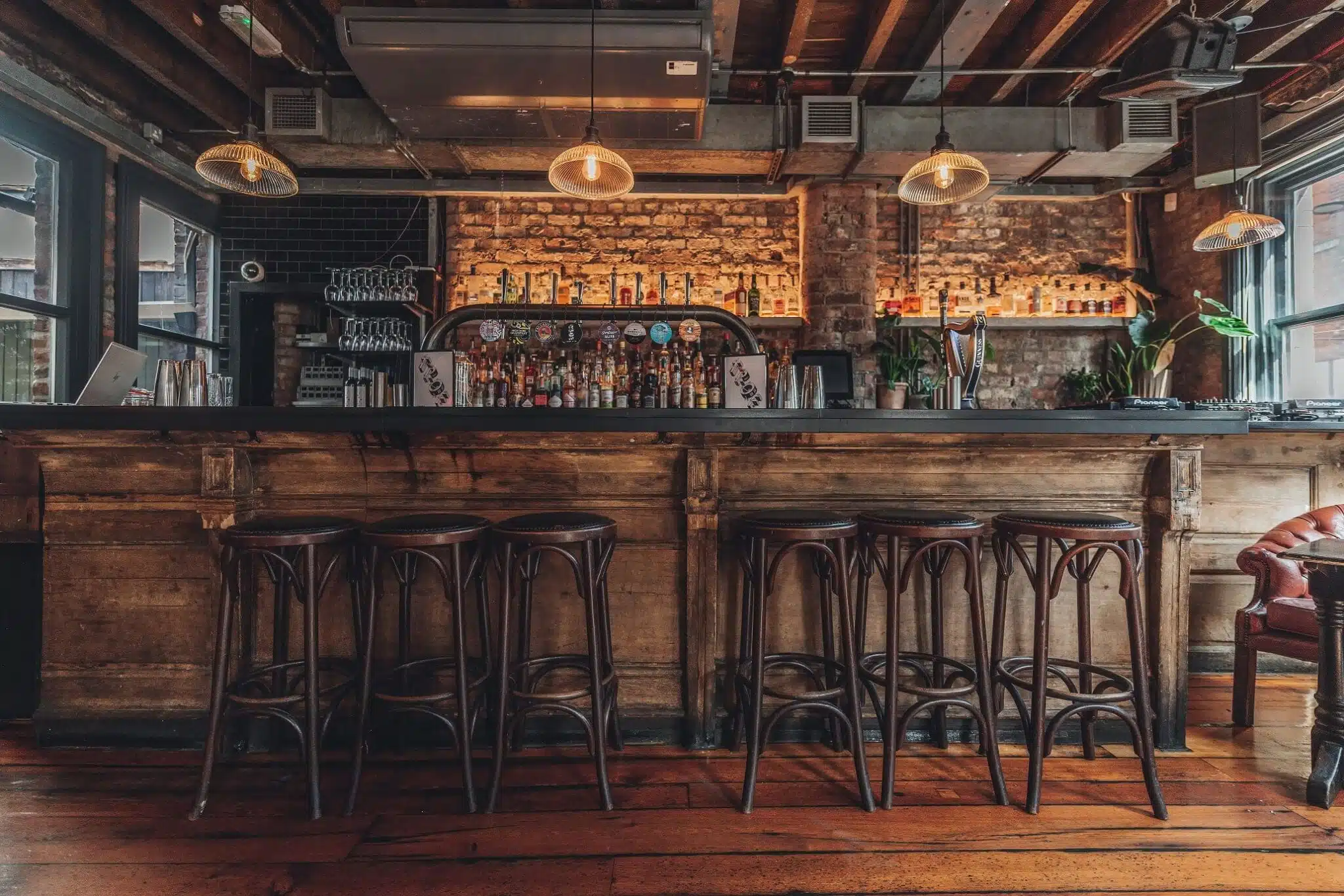 Stylish Bourbon Bar with rustic wooden counter, ideal for networking events and gatherings.