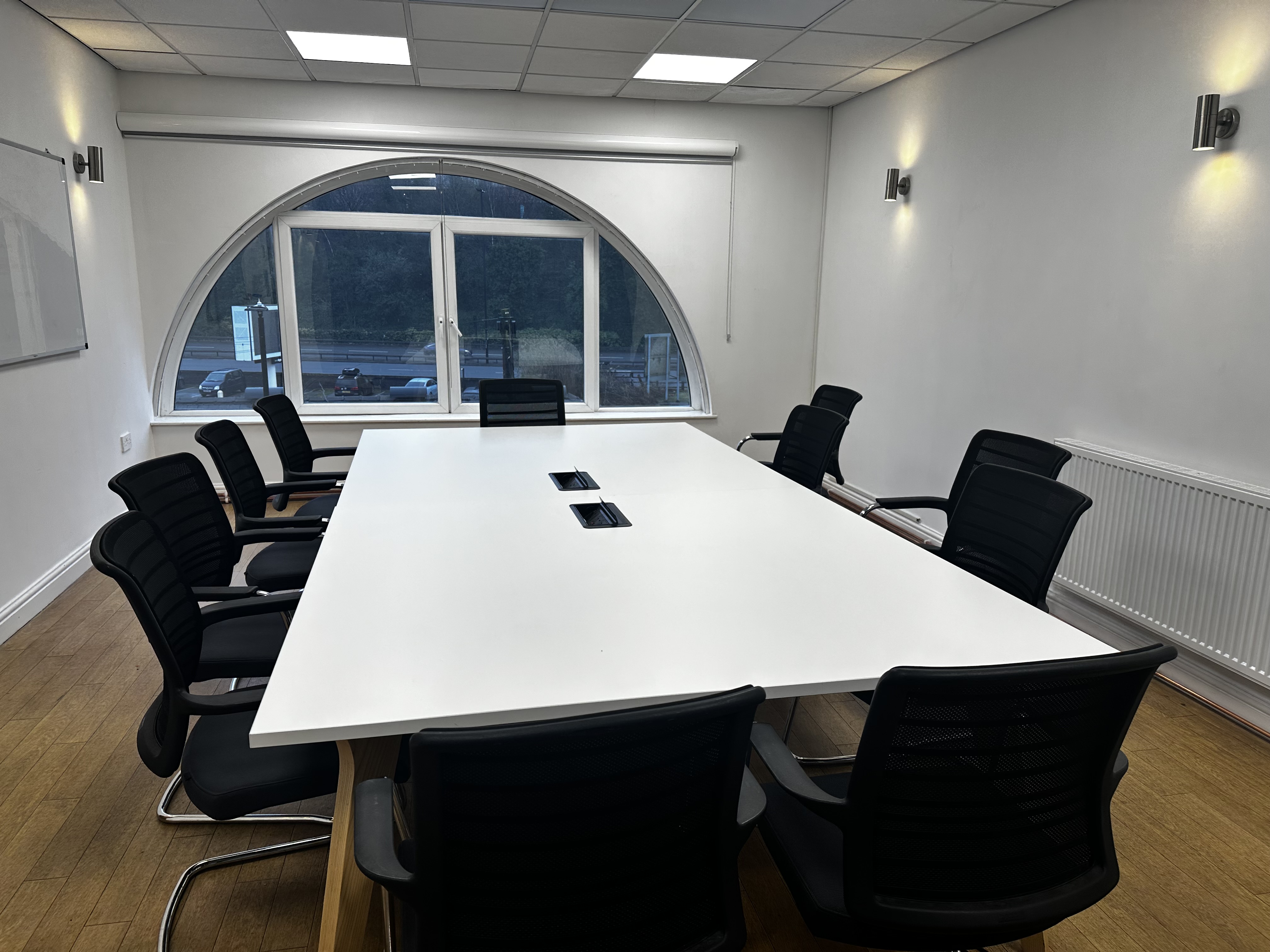 Modern Executive Suite meeting room with spacious table and natural light, ideal for events.
