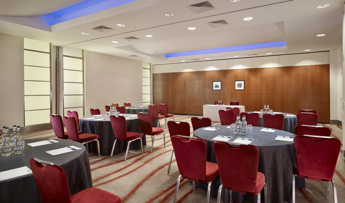 Albert Suite meeting room at Park Plaza Victoria, featuring round tables and red chairs.