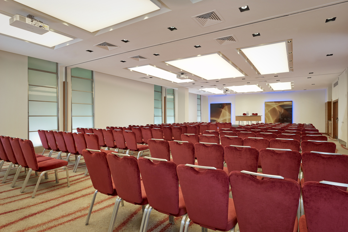 Spacious conference room with red chairs at Park Plaza Victoria, ideal for events and workshops.