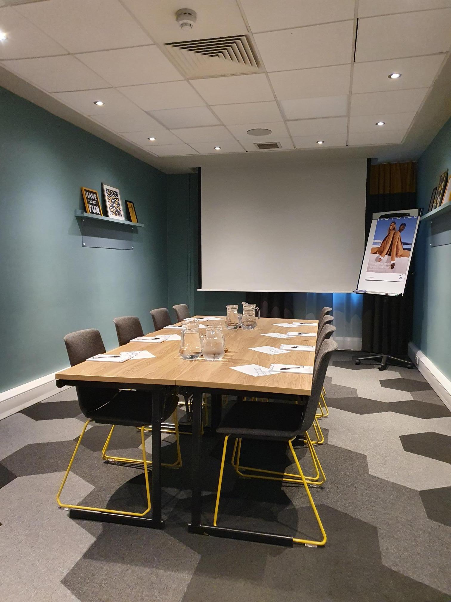 Boardroom at Novotel Edinburgh Centre: professional meeting space with projector and flipchart.
