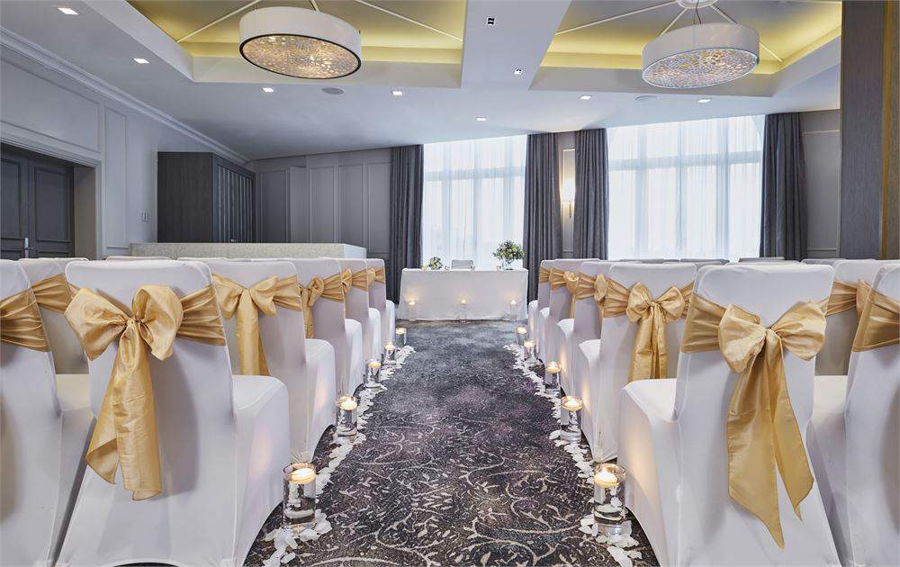 Elegant ballroom wedding ceremony setup with gold accents at Hilton Edinburgh Carlton.