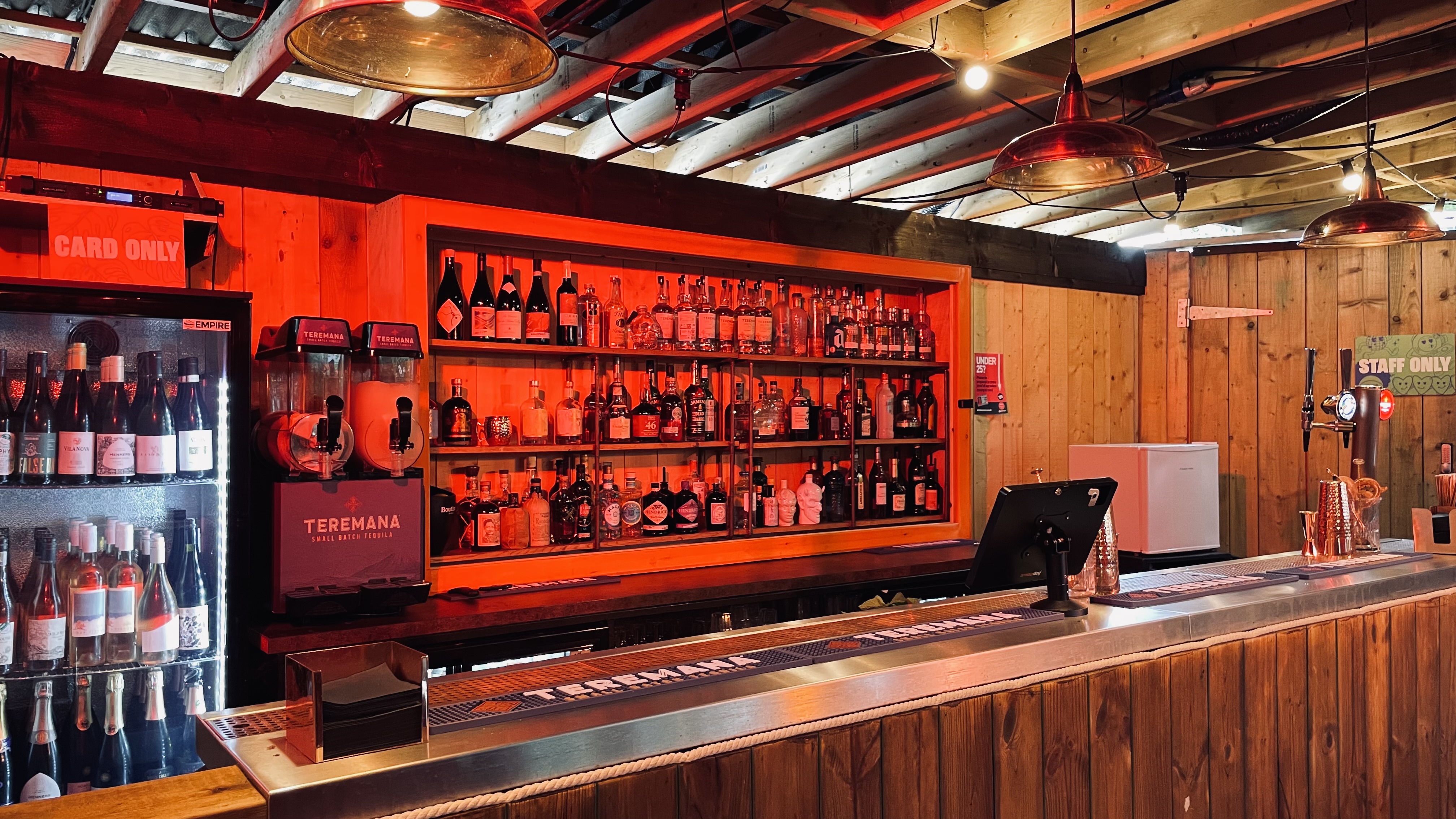 Warm wood bar at The Knot in Between The Bridges for cocktail receptions and networking.