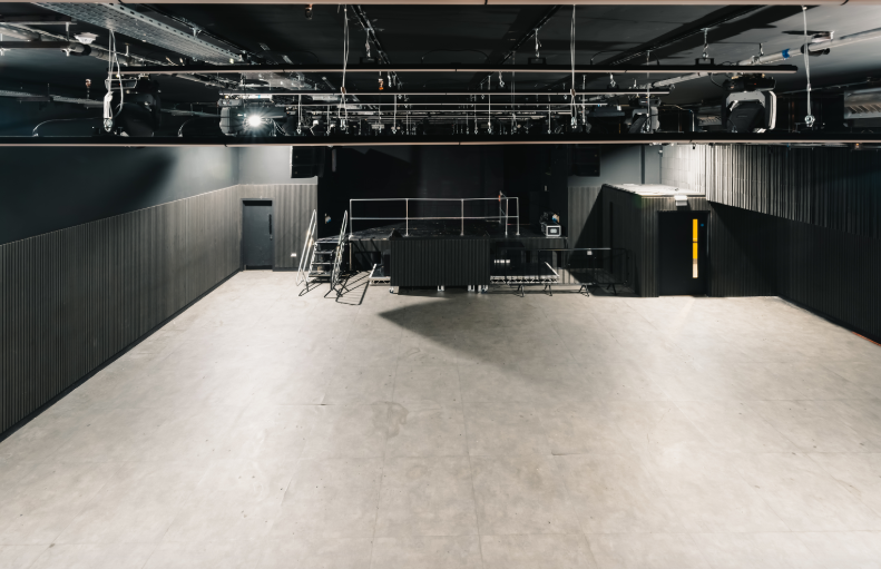 Versatile event space with a high ceiling for conferences and performances at Ambers Club.