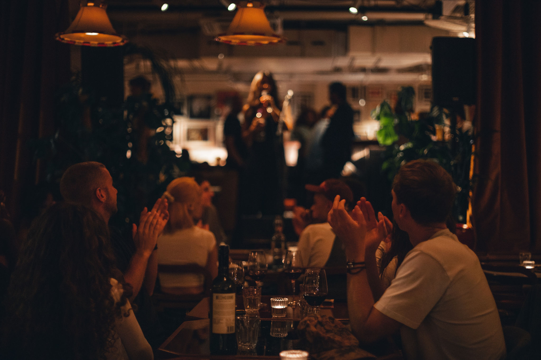 Lively Cafe KOKO event with engaged audience, warm lighting, networking and performance.