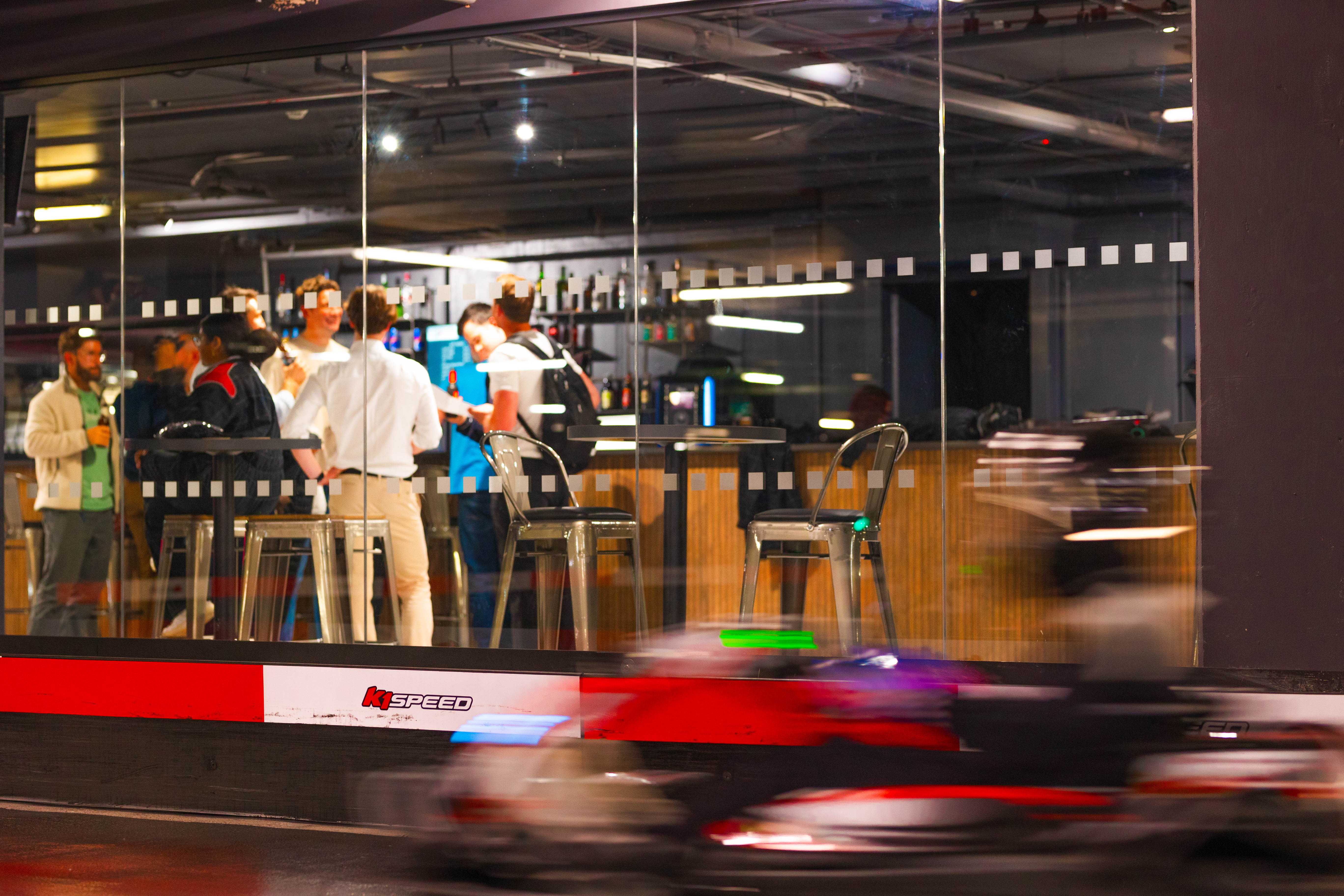 Vibrant networking event at K1 Speed Canary Wharf with high-top tables and urban energy.