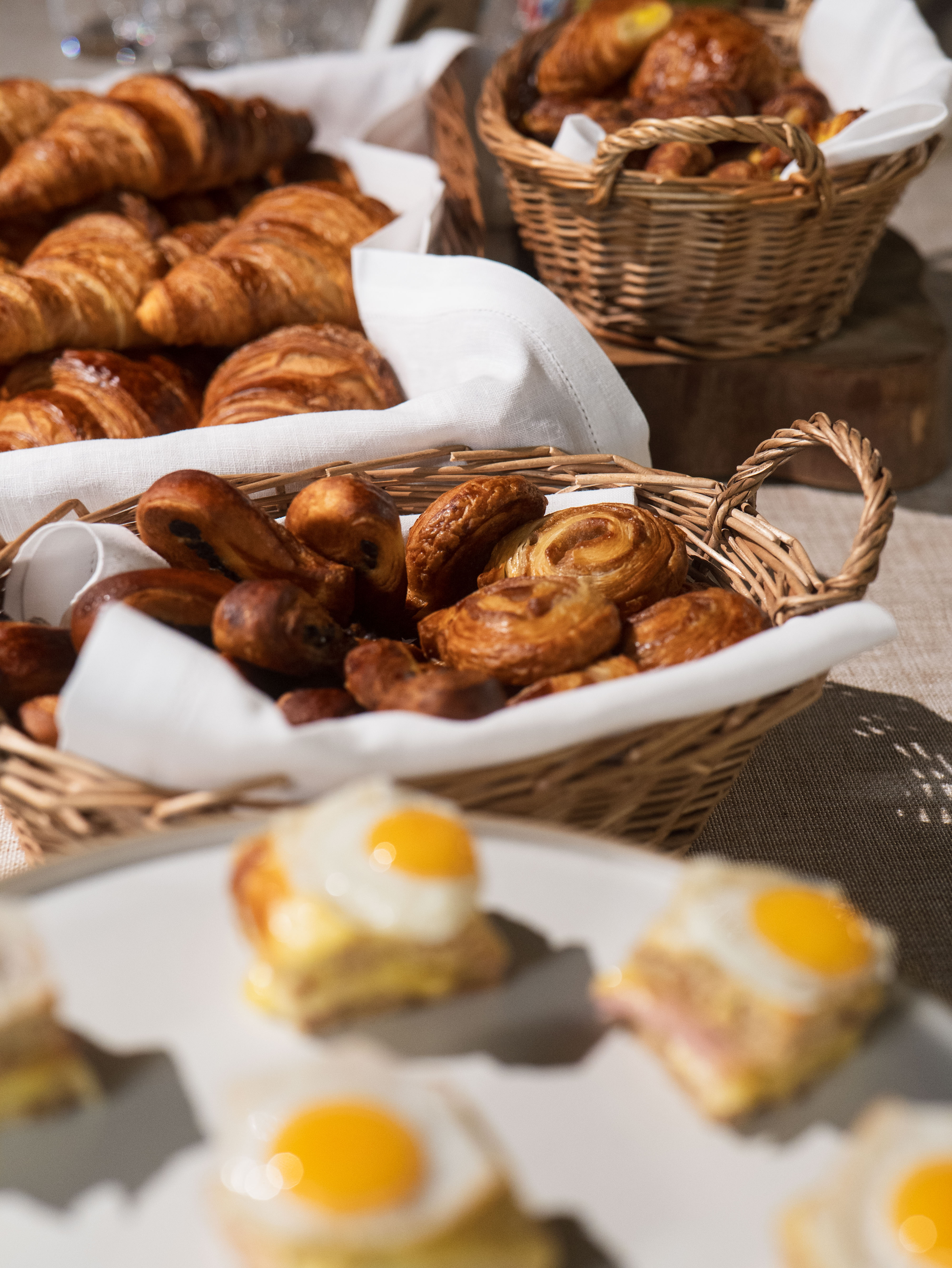 Freshly baked pastries in woven baskets at K1 Speed Canary Wharf networking event.