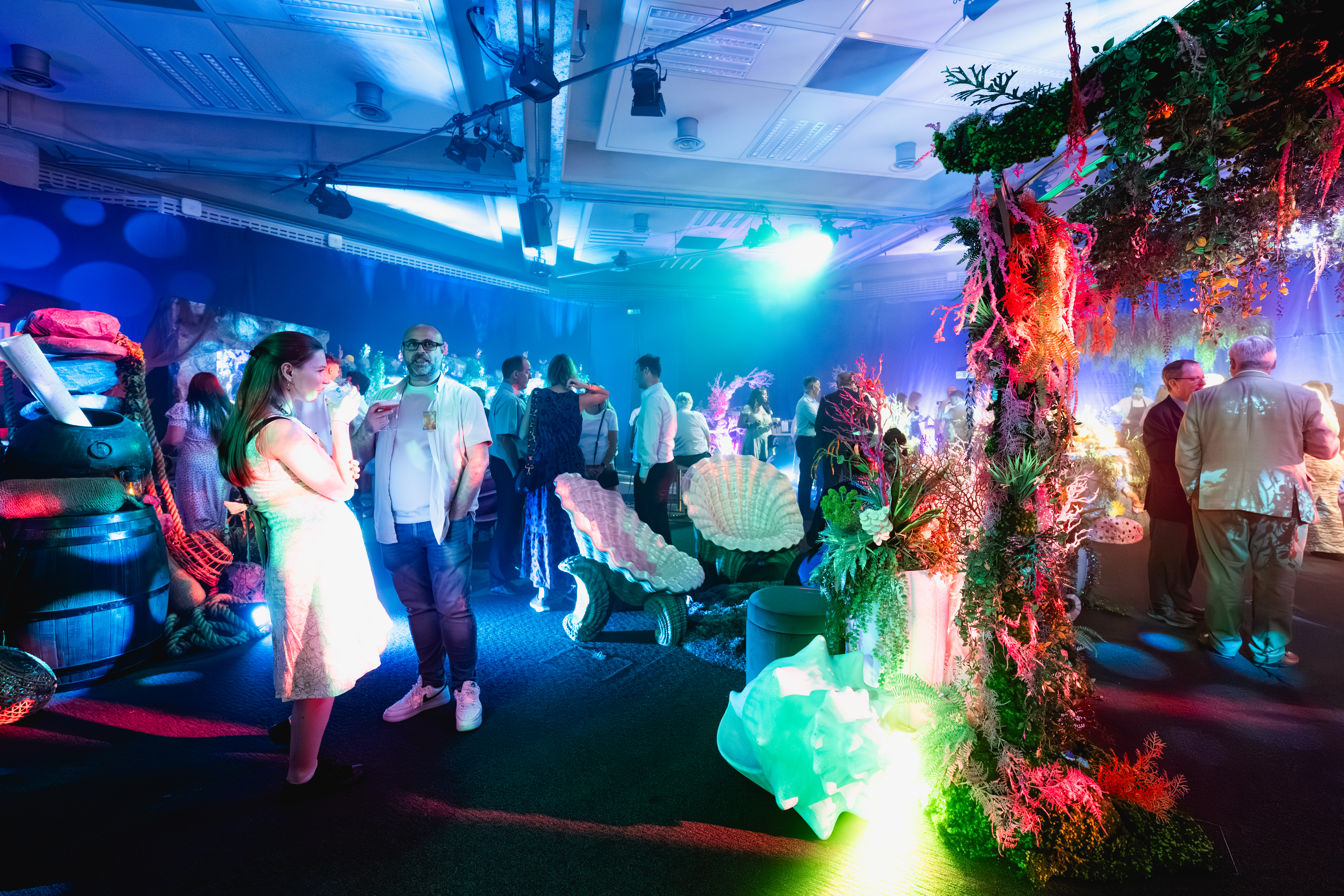 Vibrant event space with floral decor for networking at QEII Centre.