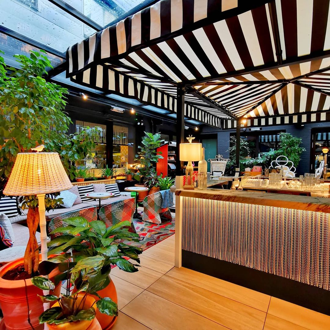 Stylish Garden Bar at Mama Shelter London with striped canopy for events and gatherings.