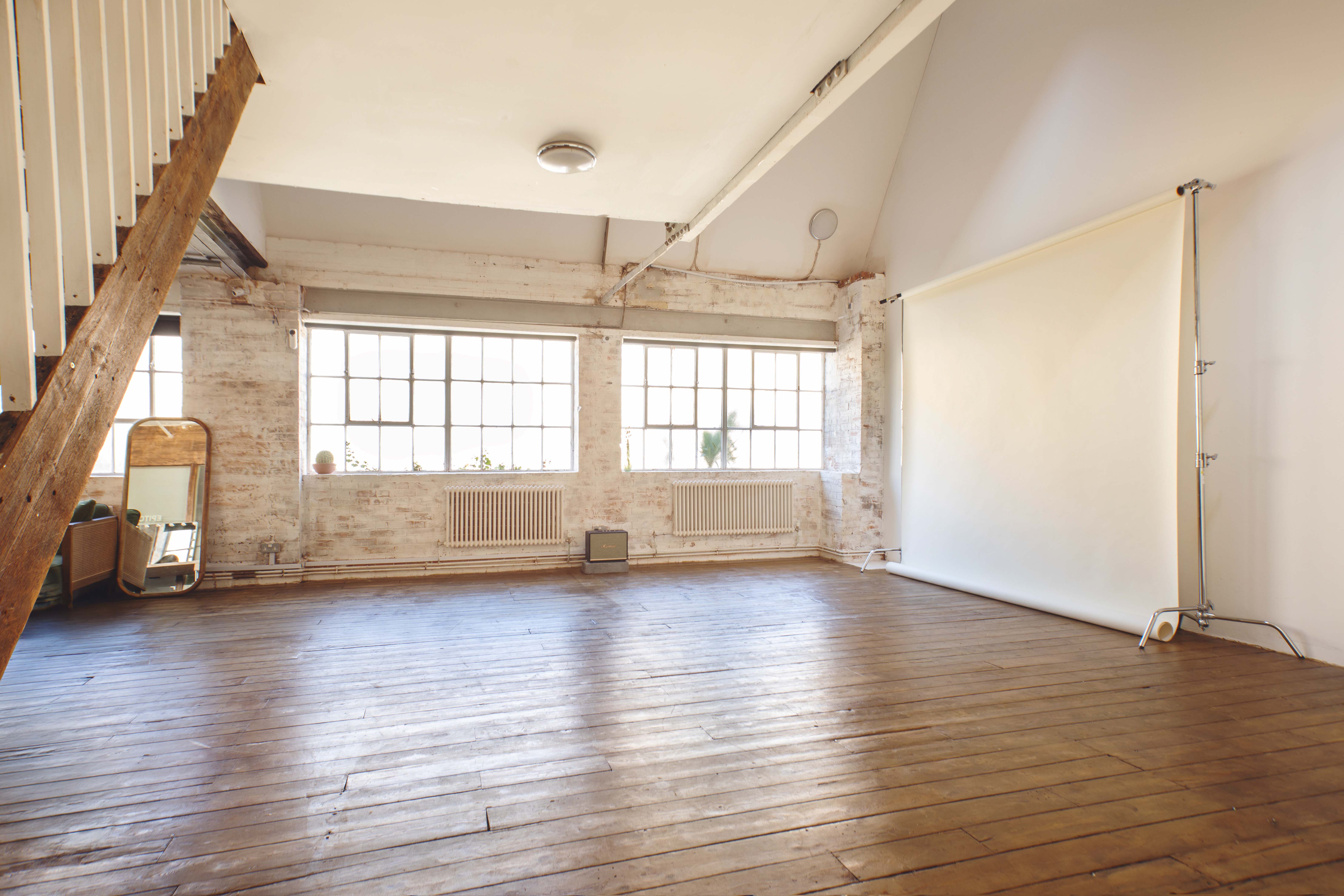 Industrial-chic loft studio with exposed wood for creative workshops and photo shoot events.