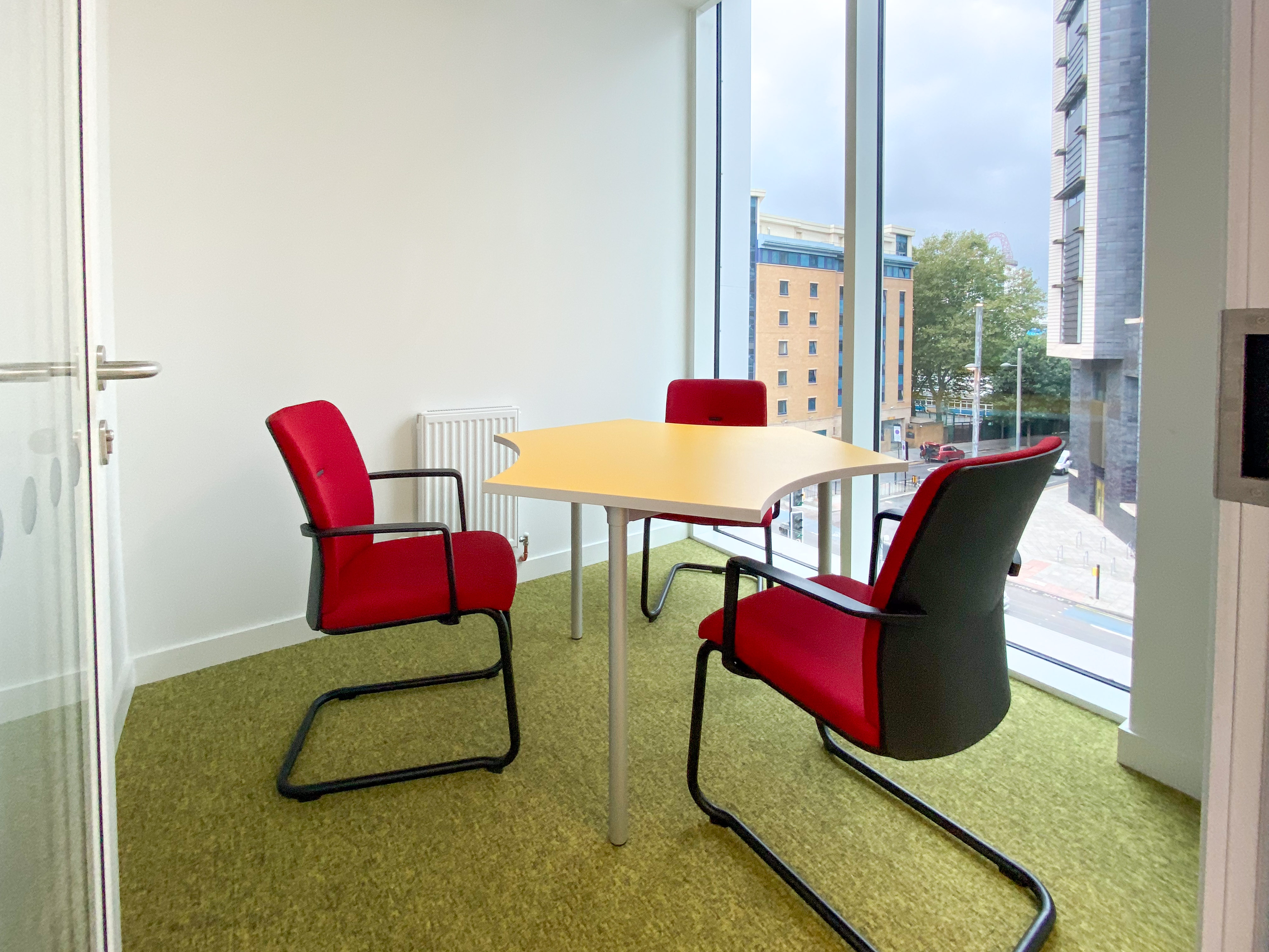Modern consultation room with red chairs, ideal for meetings and brainstorming sessions.