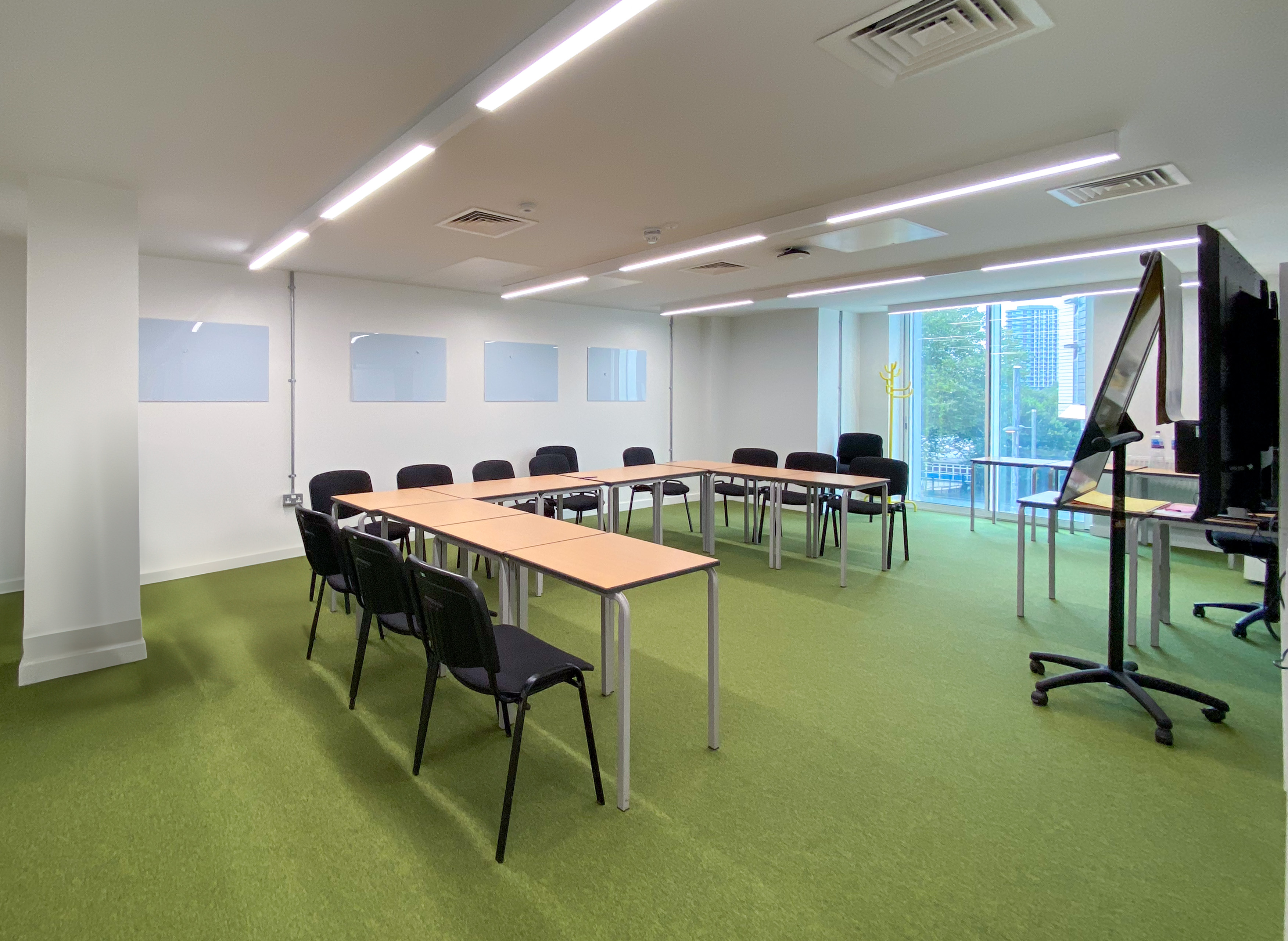 Versatile meeting room with U-shaped table, ideal for workshops and conferences.
