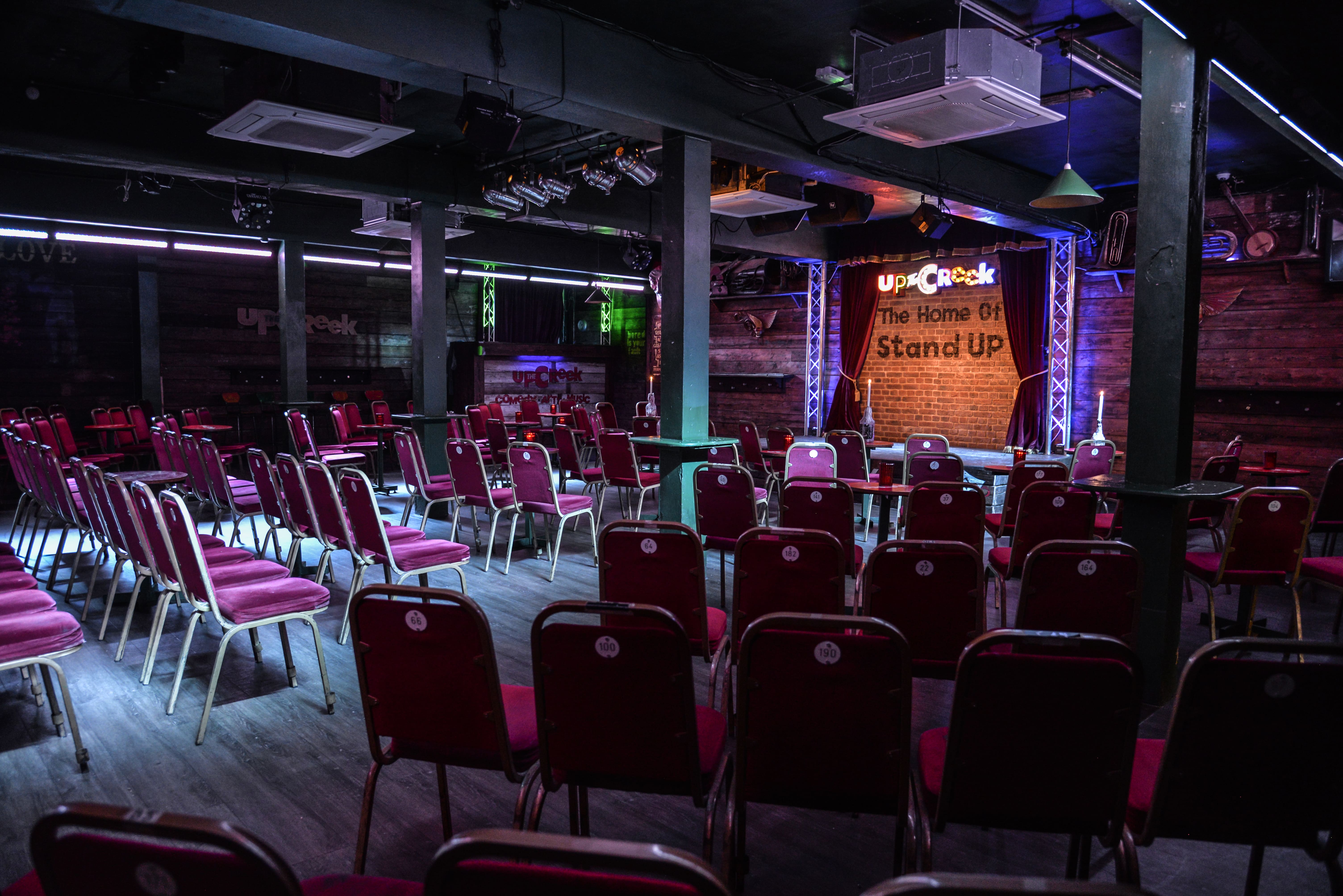 Intimate event space for stand-up comedy with vibrant decor and seating arrangement.