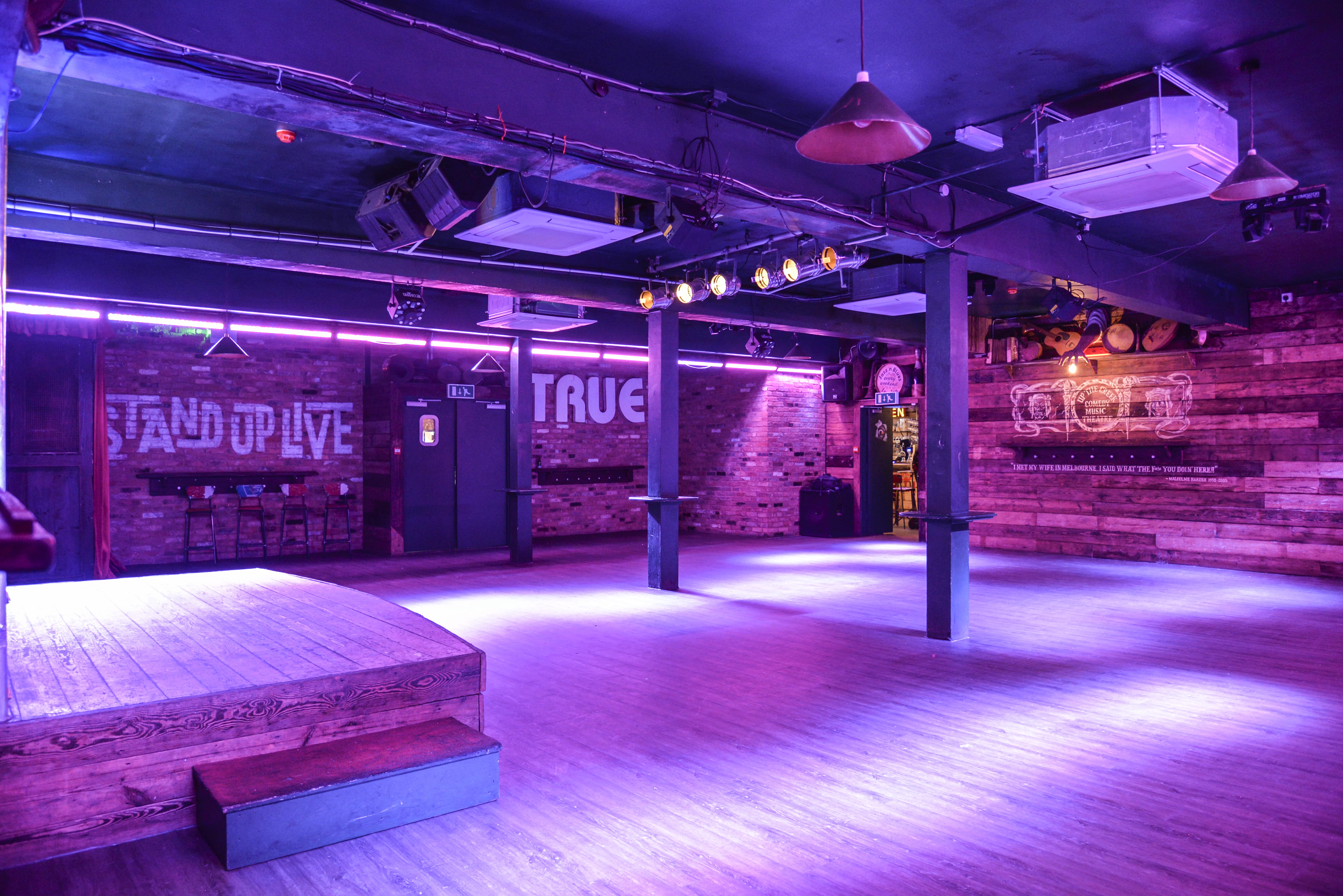 Versatile event space with an elevated stage for corporate and creative gatherings.