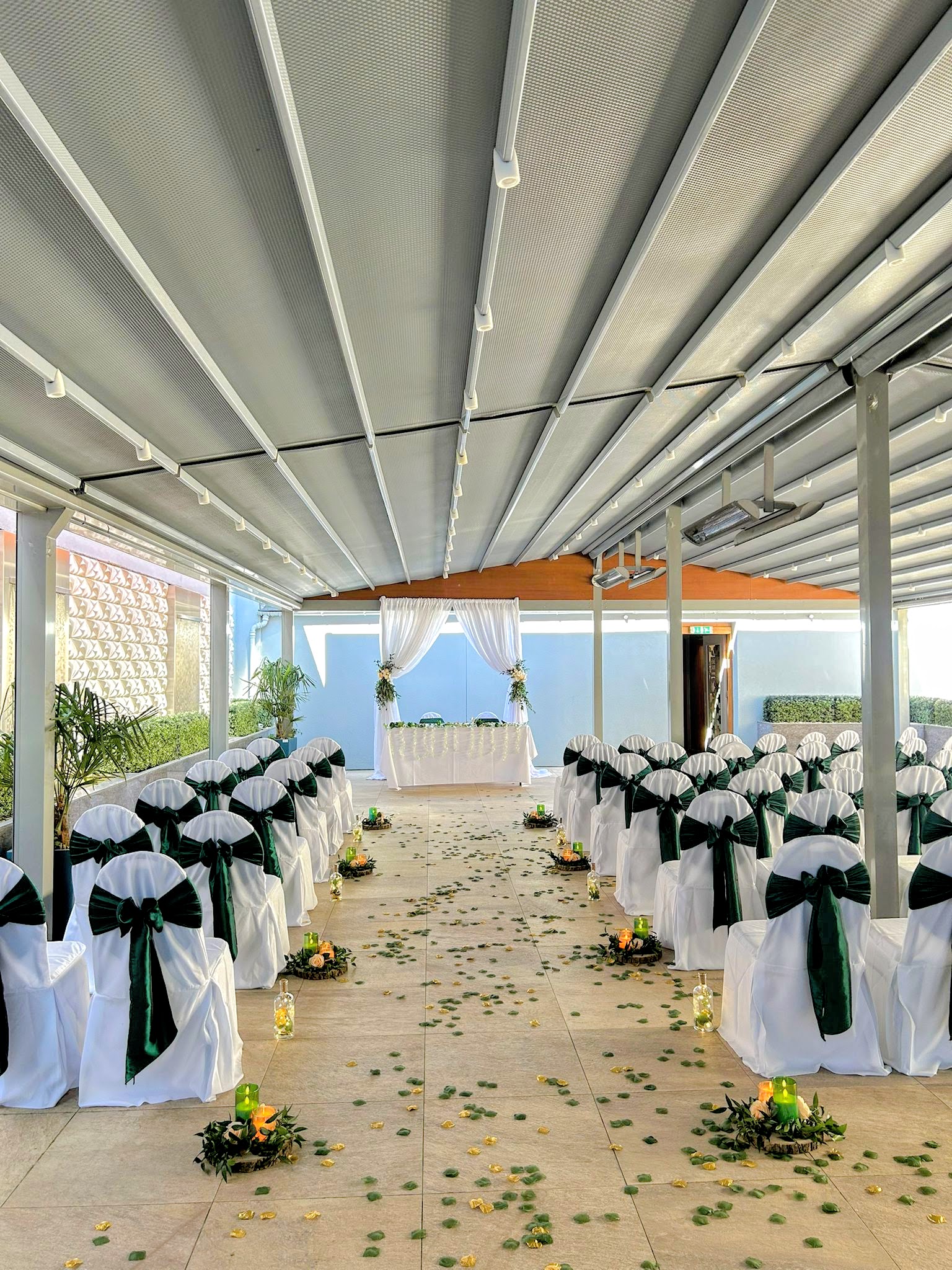 Elegant wedding venue with white chairs and green sashes at The York, The Place Hotel.