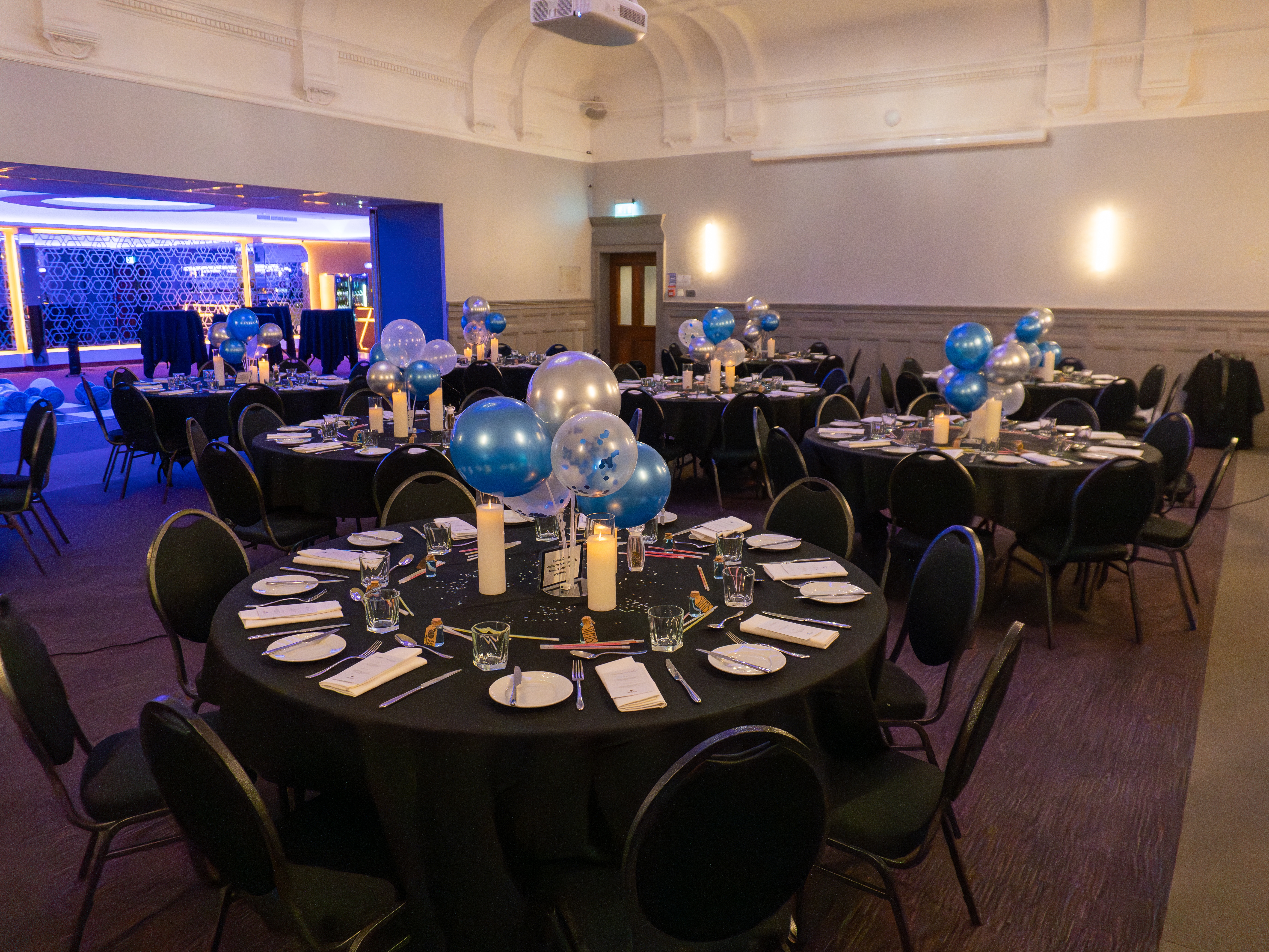 Elegant event space at The York, featuring round tables and festive balloon centerpieces.