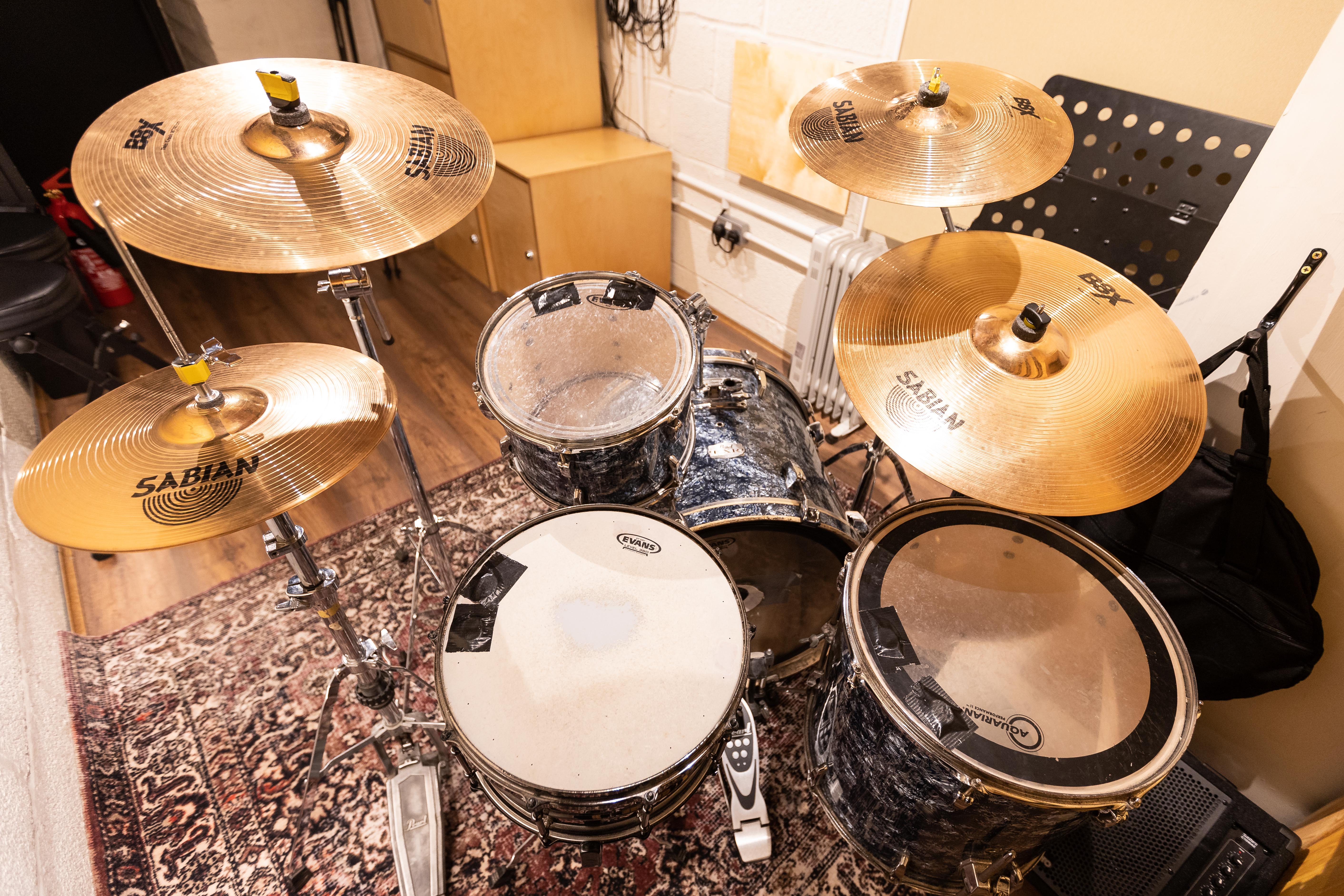 Small room backline setup at Yellow Hat Studios featuring exposed cables; event production hazard.