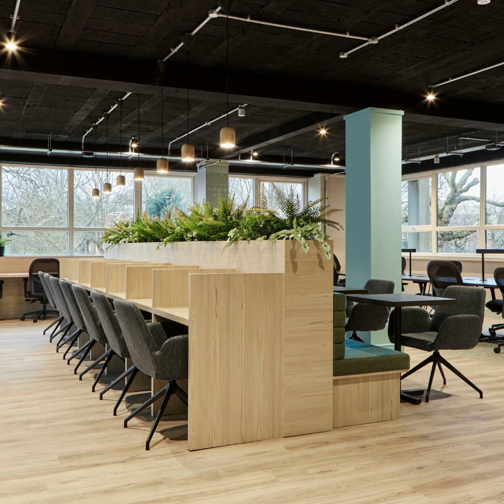 Modern coworking meeting room with biophilic design for hybrid work and team brainstorming.