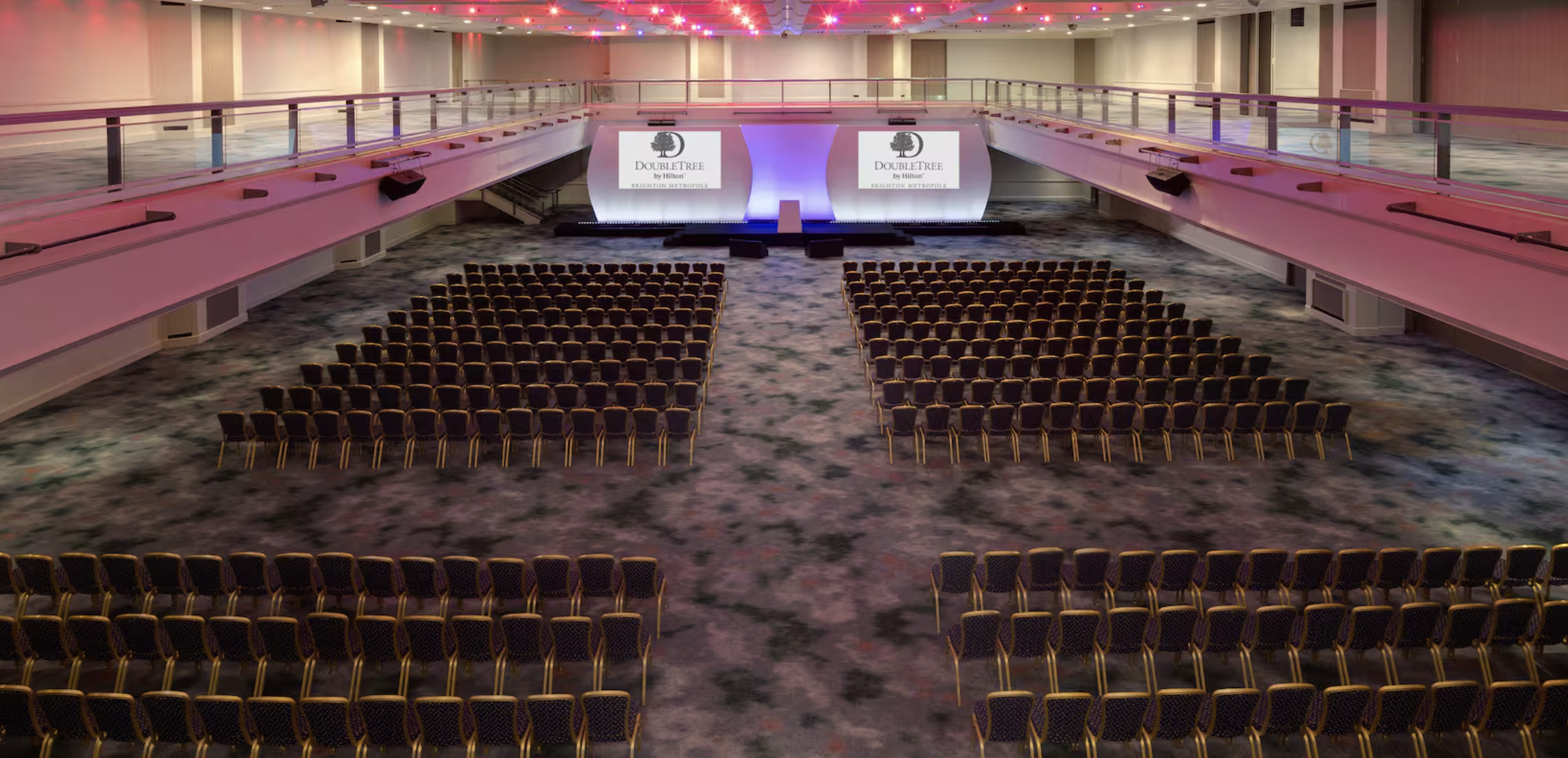 Spacious conference hall at DoubleTree Brighton for large events with dual screens.