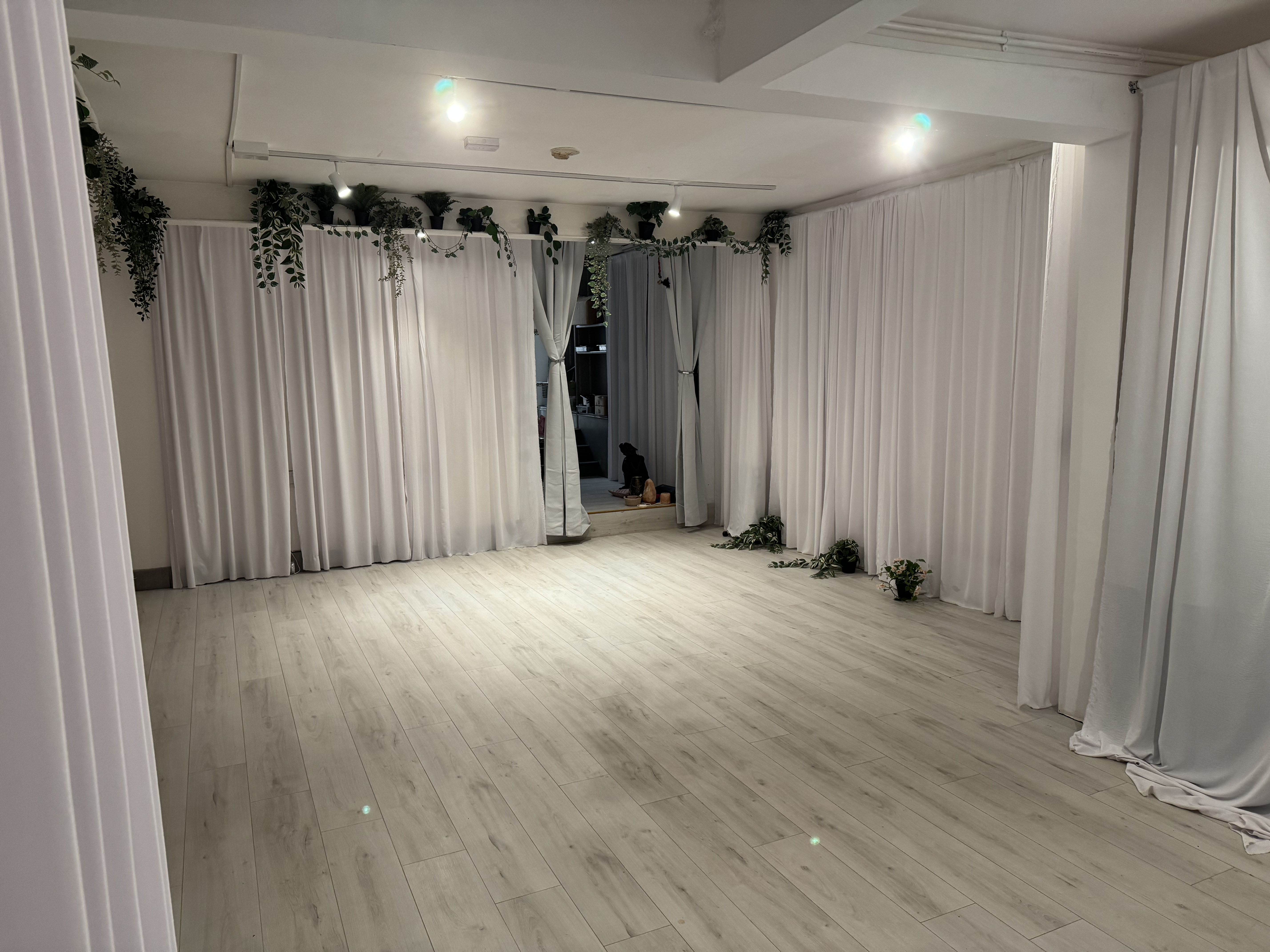 Minimalist event studio with wood floors for boutique workshops and yoga sessions.