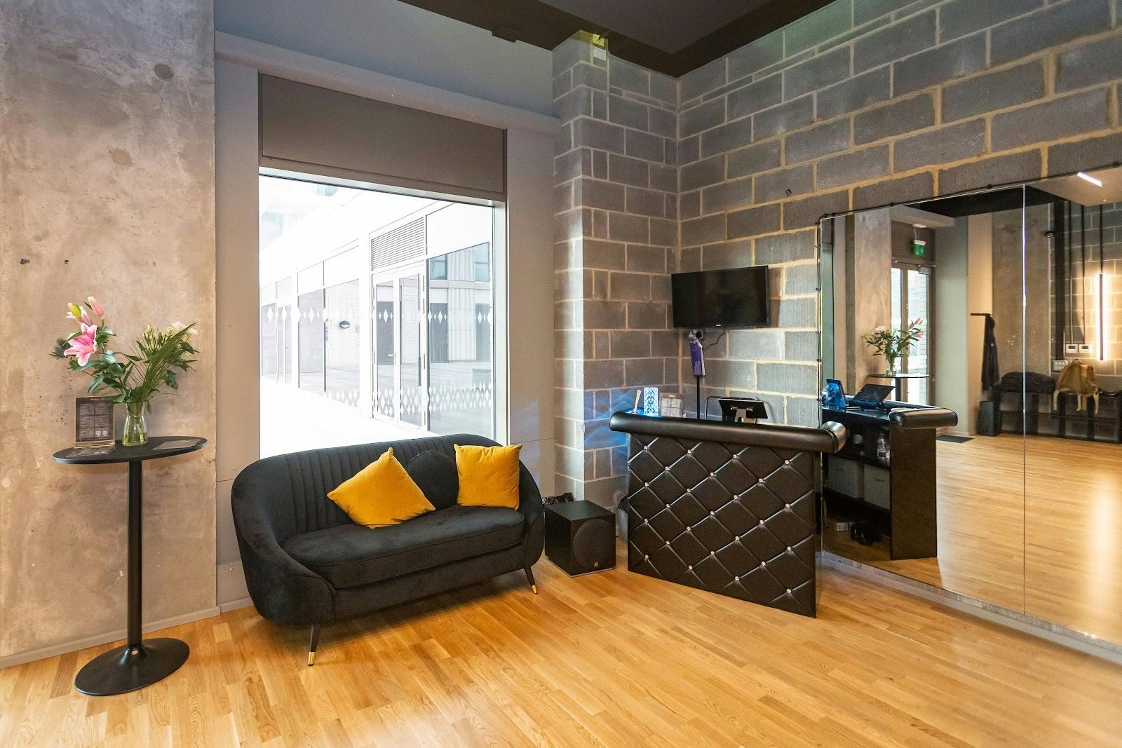 Industrial-chic studio reception with wood floors for corporate events and workshops.