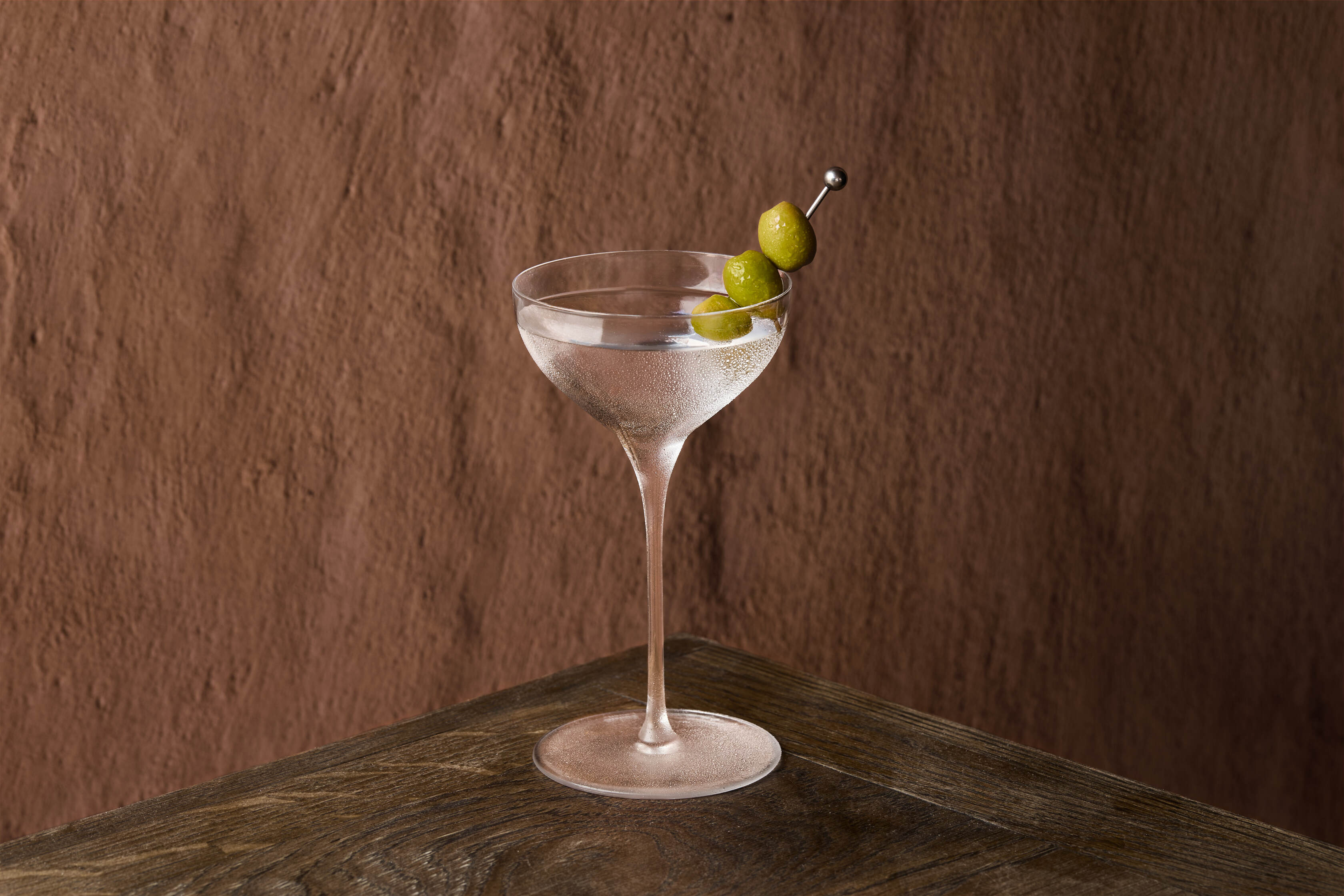 Elegant martini glass with olives at Pyro Restaurant for upscale events.