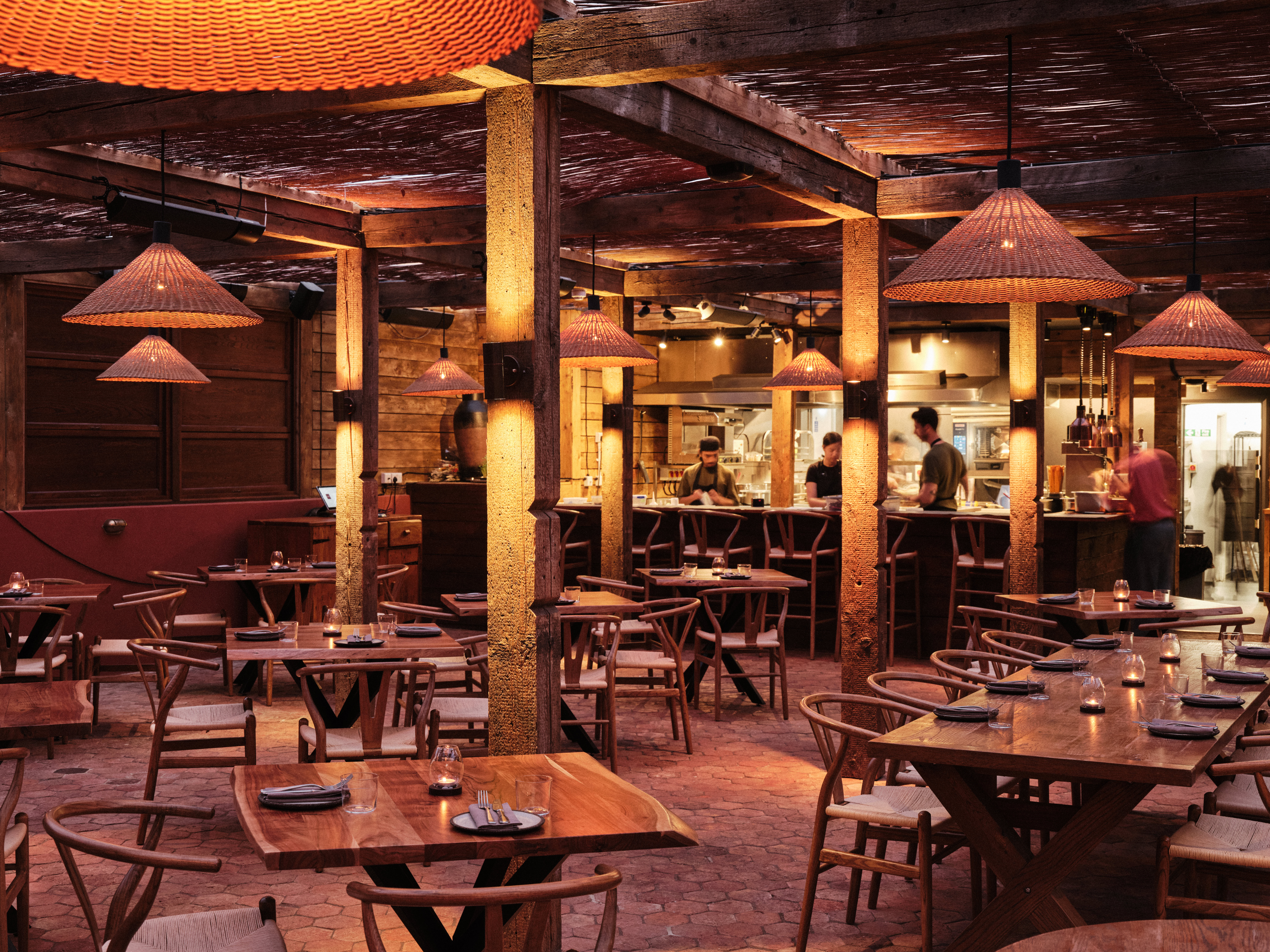 Vibrant rustic Pyro Restaurant with warm lighting for gatherings and workshops.