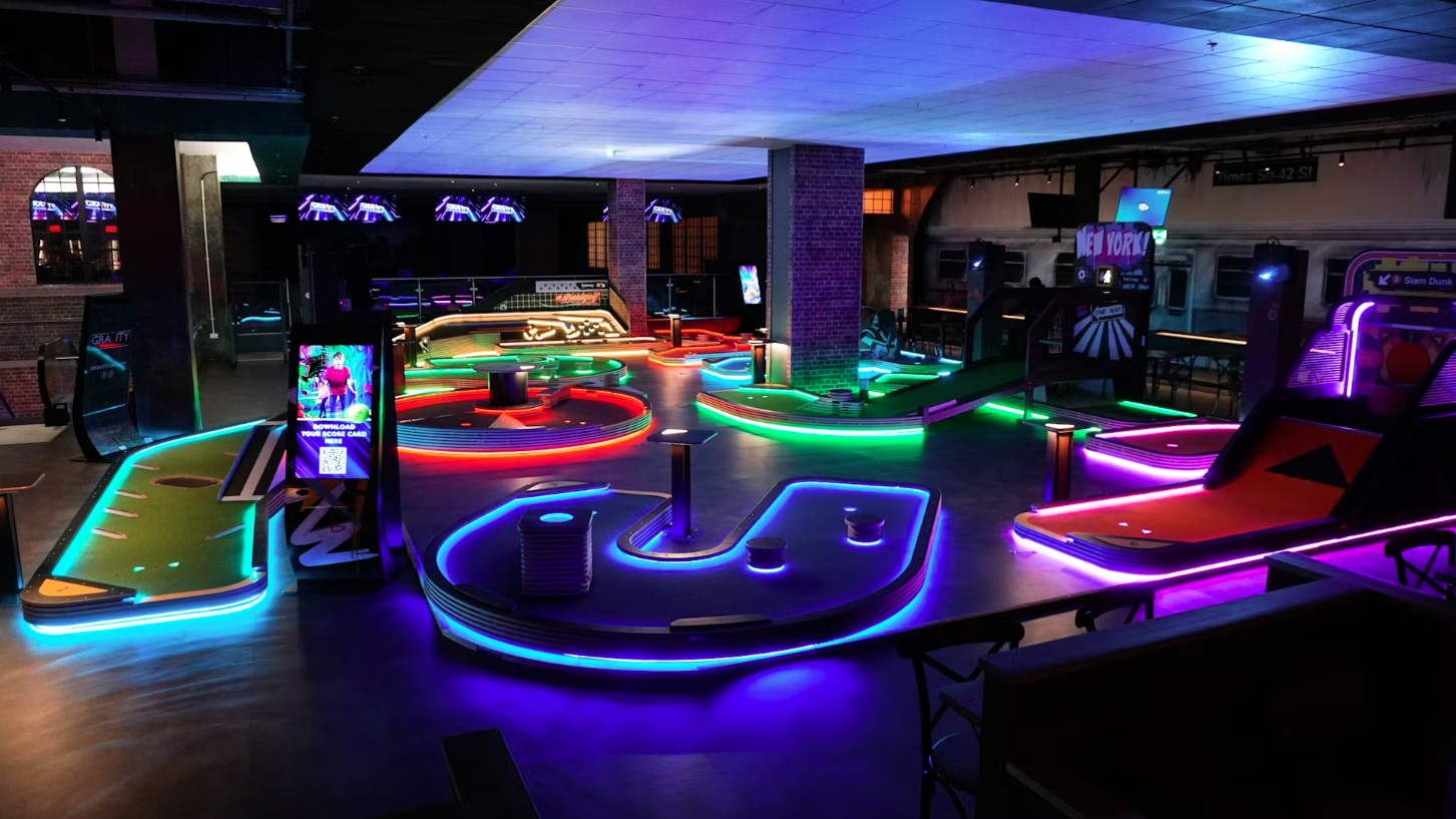 Vibrant neon mini golf course at Gravity Wandsworth for events and team-building.