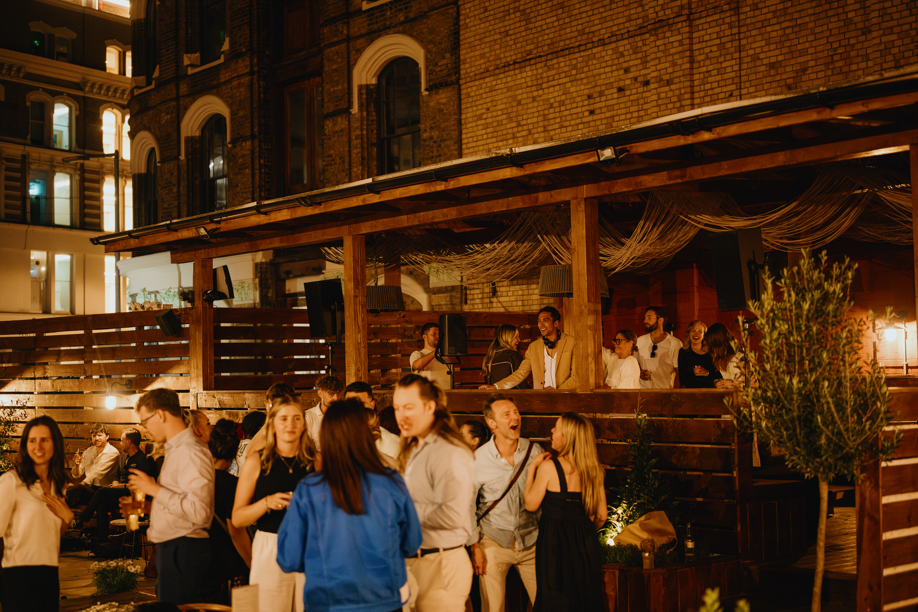 Vibrant outdoor networking event at Pyro Full Venue with rustic charm and greenery.