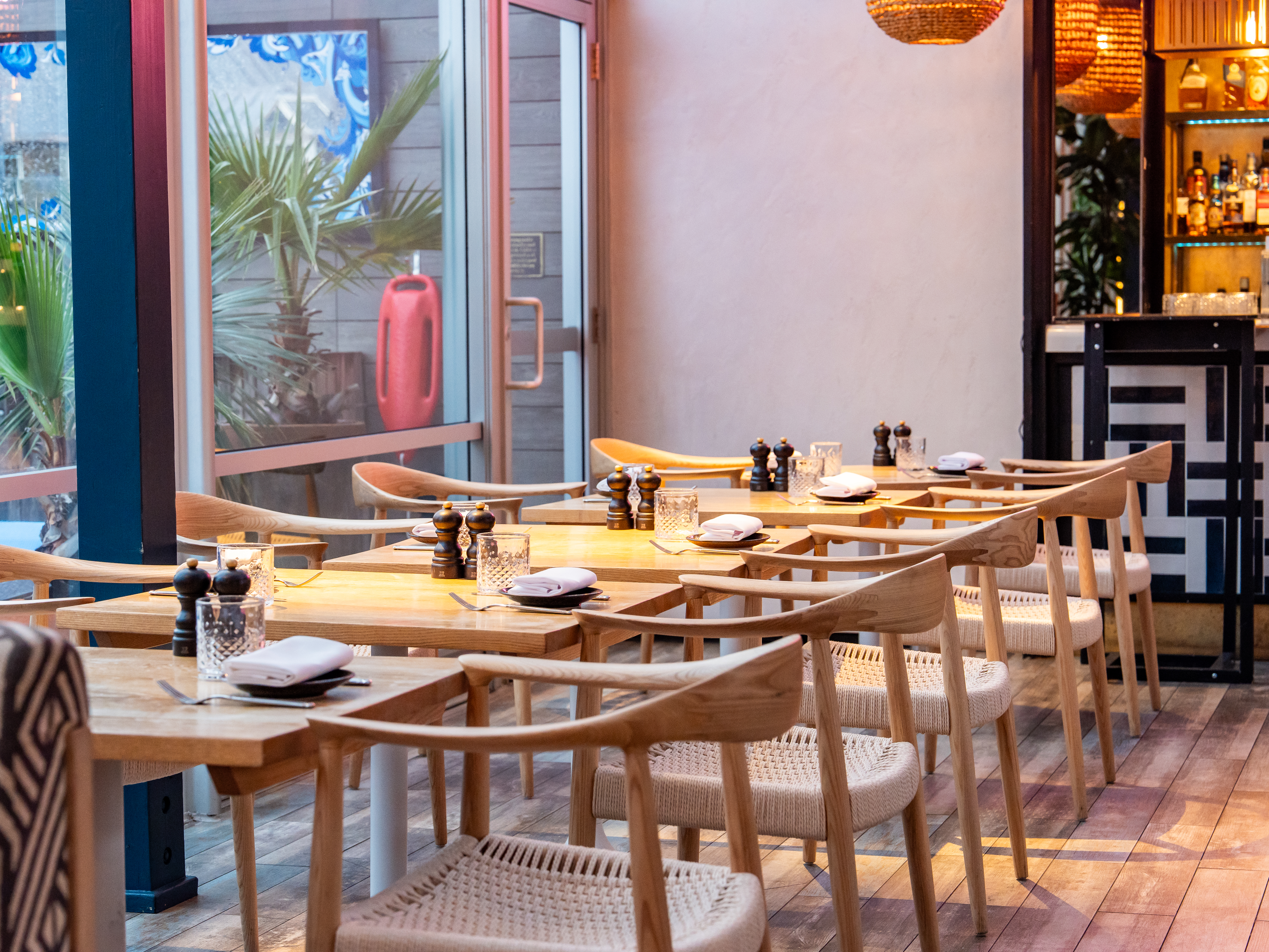 Stylish dining area with natural wood tables, ideal for intimate corporate events.