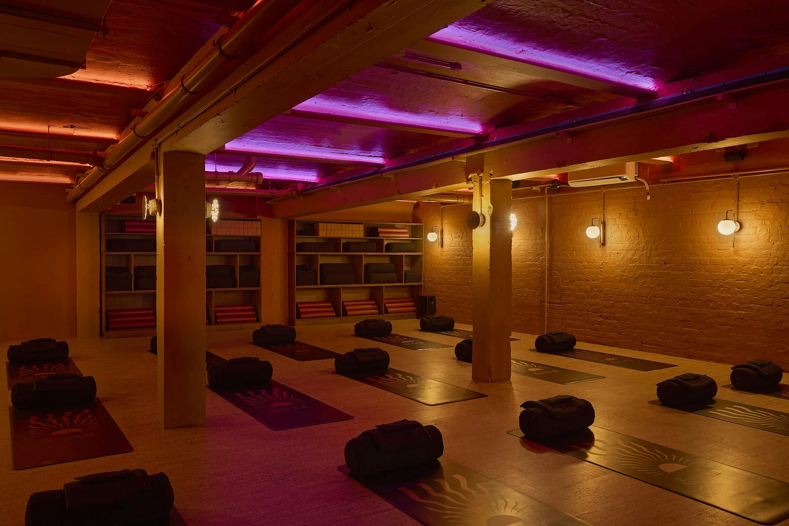 Industrial-chic wellness studio with mood lighting for corporate retreats and breakout sessions.