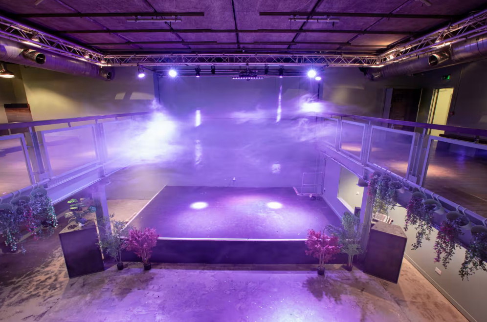 Acres23 industrial-chic event venue with stage, ideal for product launches and modern receptions.