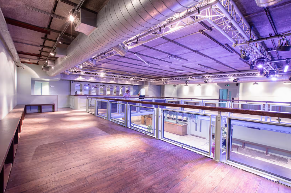 Industrial-chic mezzanine at Acres23 event venue, ideal for VIP lounge or break-out sessions.