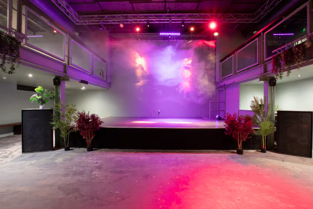 Acres23 industrial event venue with stage lighting, perfect for product launches and performances.