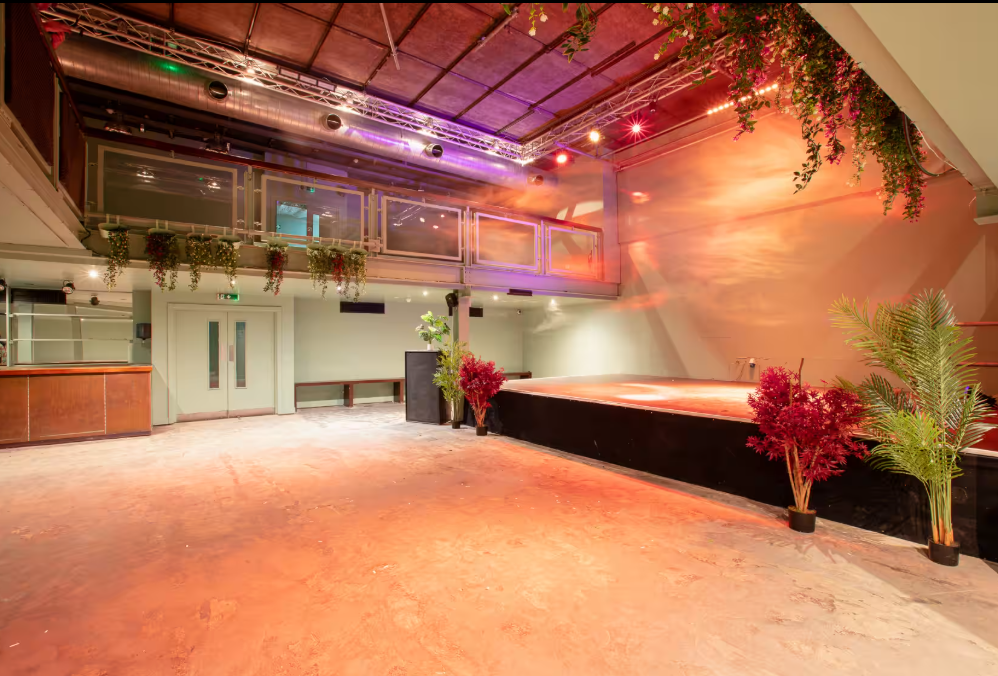 Acres23 industrial event venue with stage, ideal for corporate receptions and live performances.