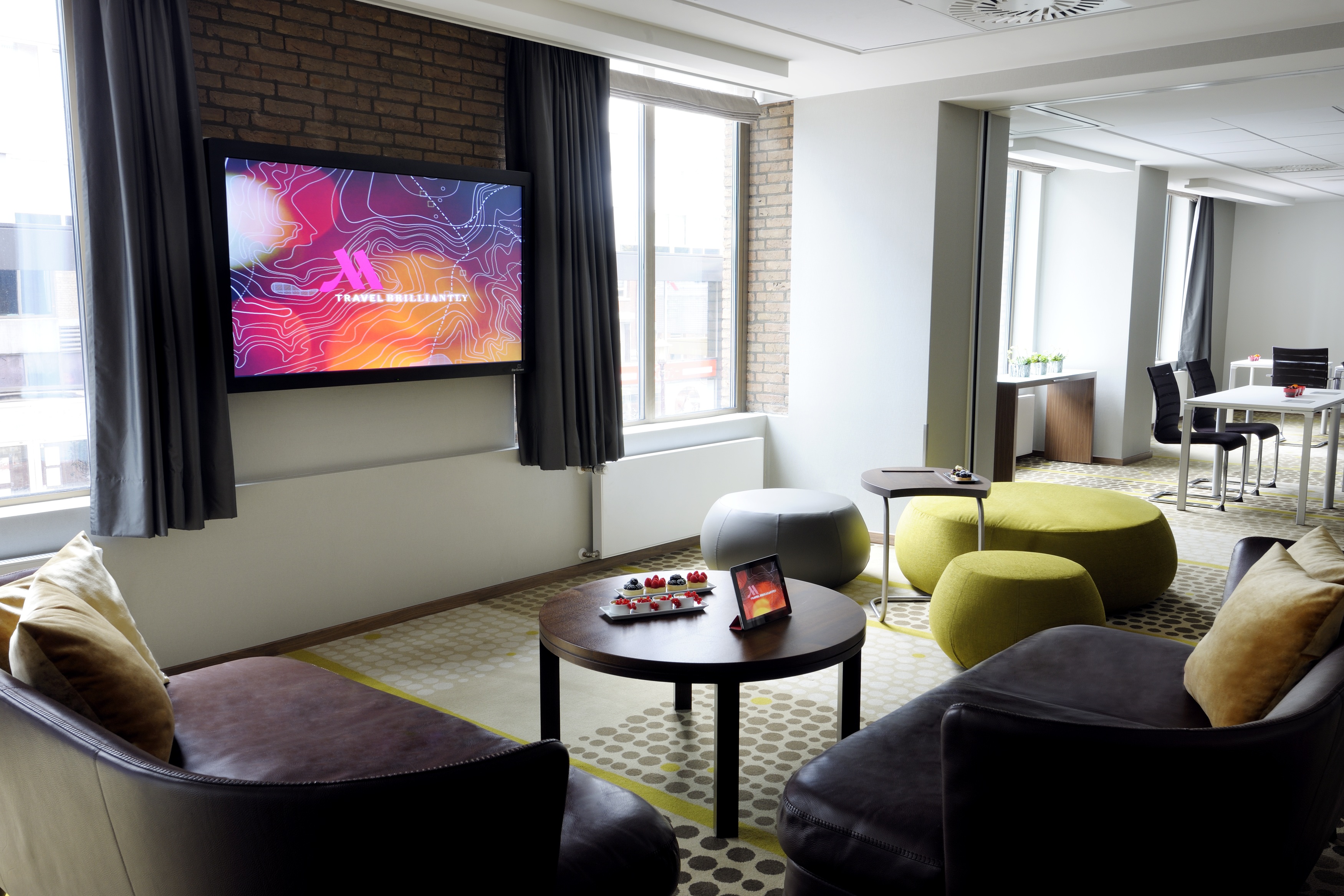 Modern meeting space with large screen at Amsterdam Marriott for conferences and networking.