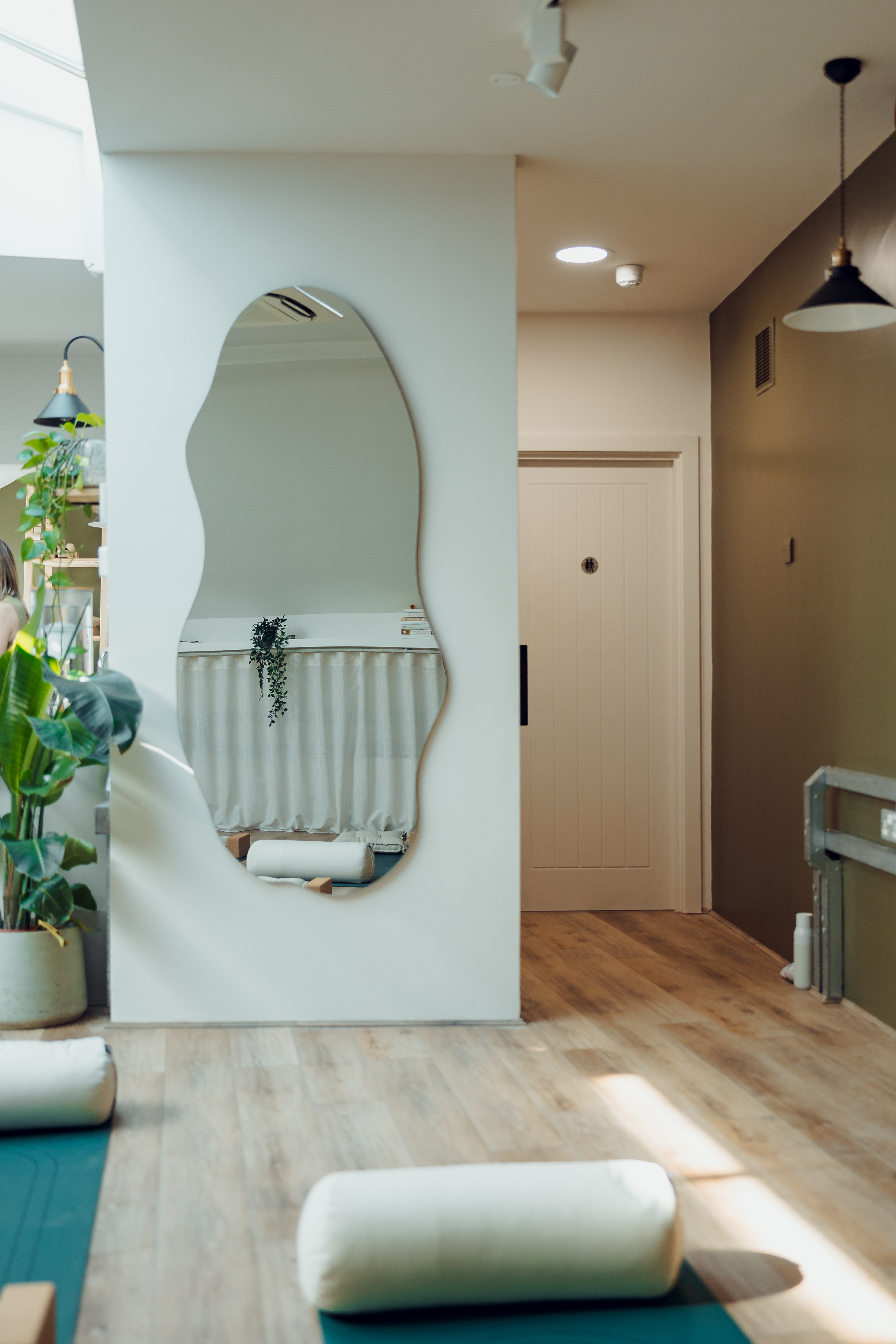 Calm wellness studio with organic mirror for corporate retreats and mindfulness workshops.