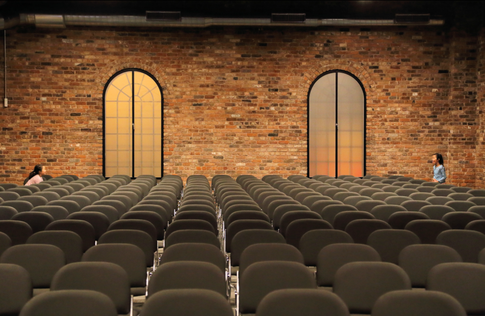 Industrial-chic event venue with exposed brick, perfect for corporate keynotes and presentations.