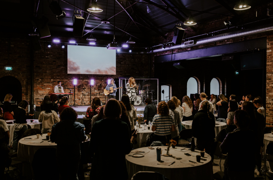 Industrial-chic Gas Street Church venue with stage lighting for corporate event and conferences.