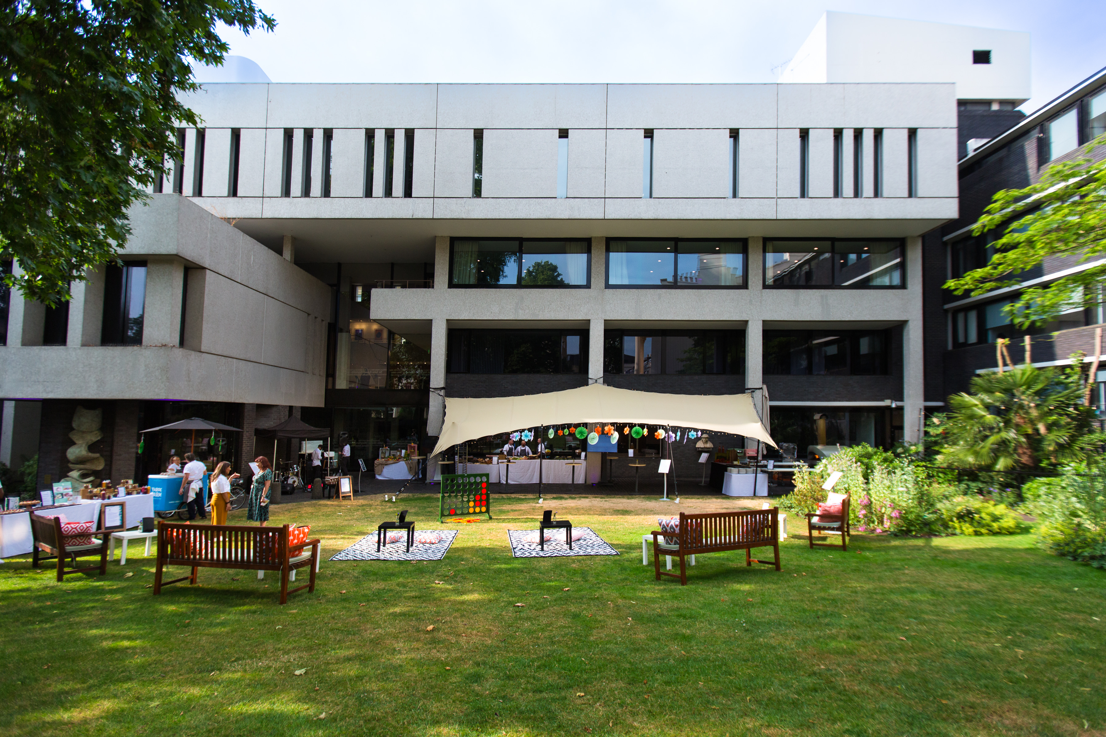 Outdoor event space at RCP London with modern architecture and lush greenery.