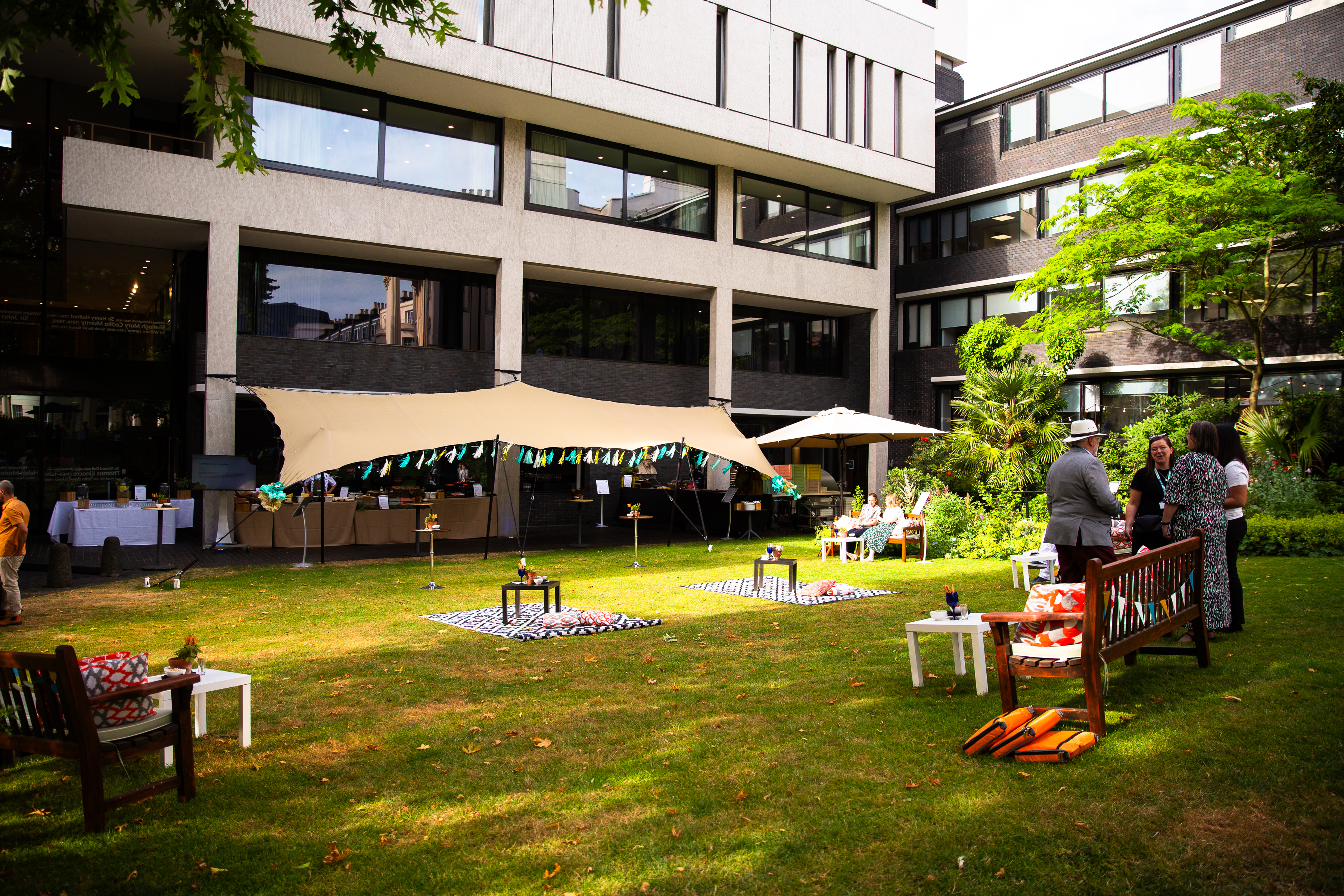 Outdoor corporate event at RCP London with elegant tent and lush green lawn.