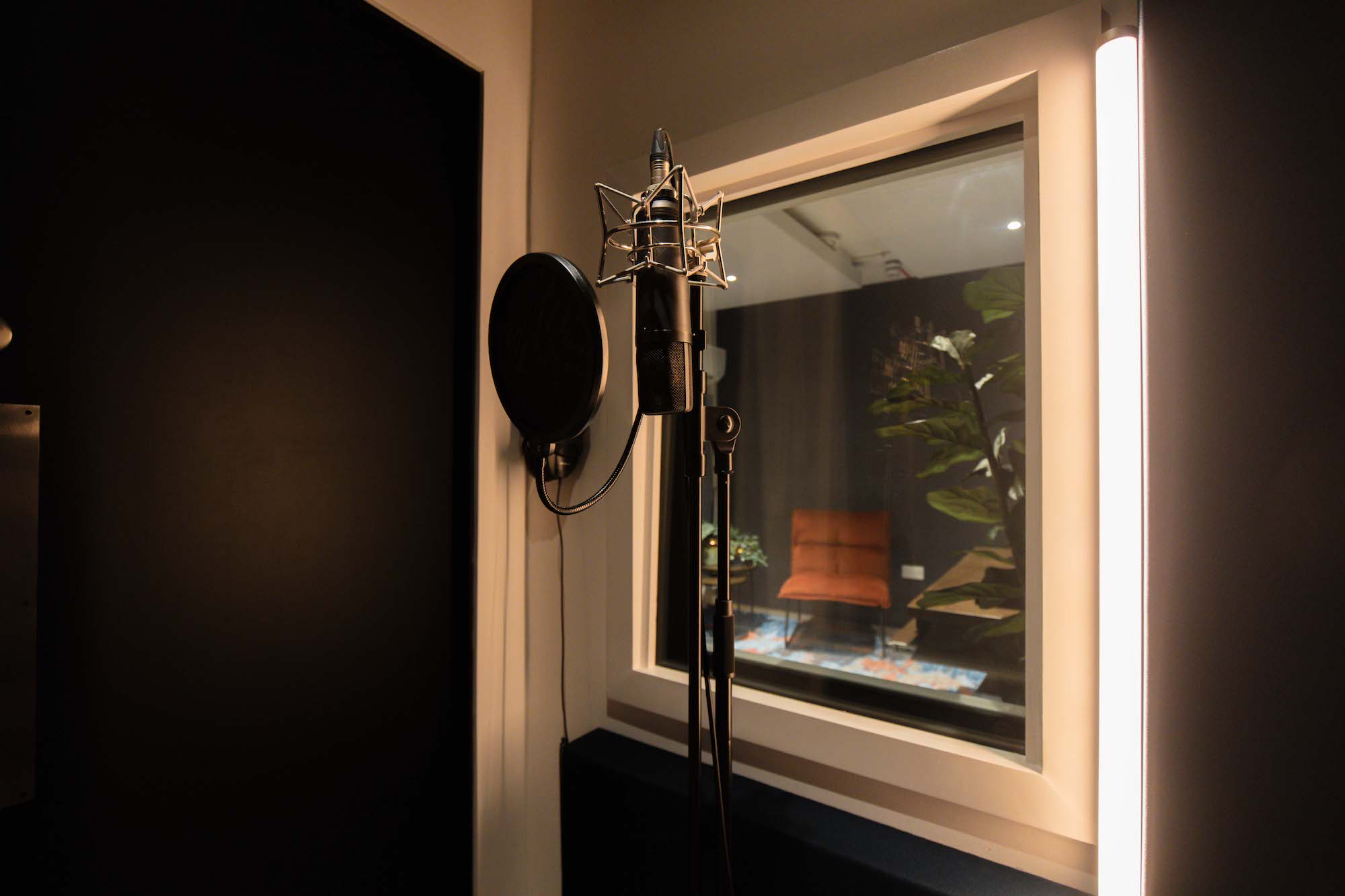 Sleek recording booth with microphone in West London studio for corporate podcasts and events.