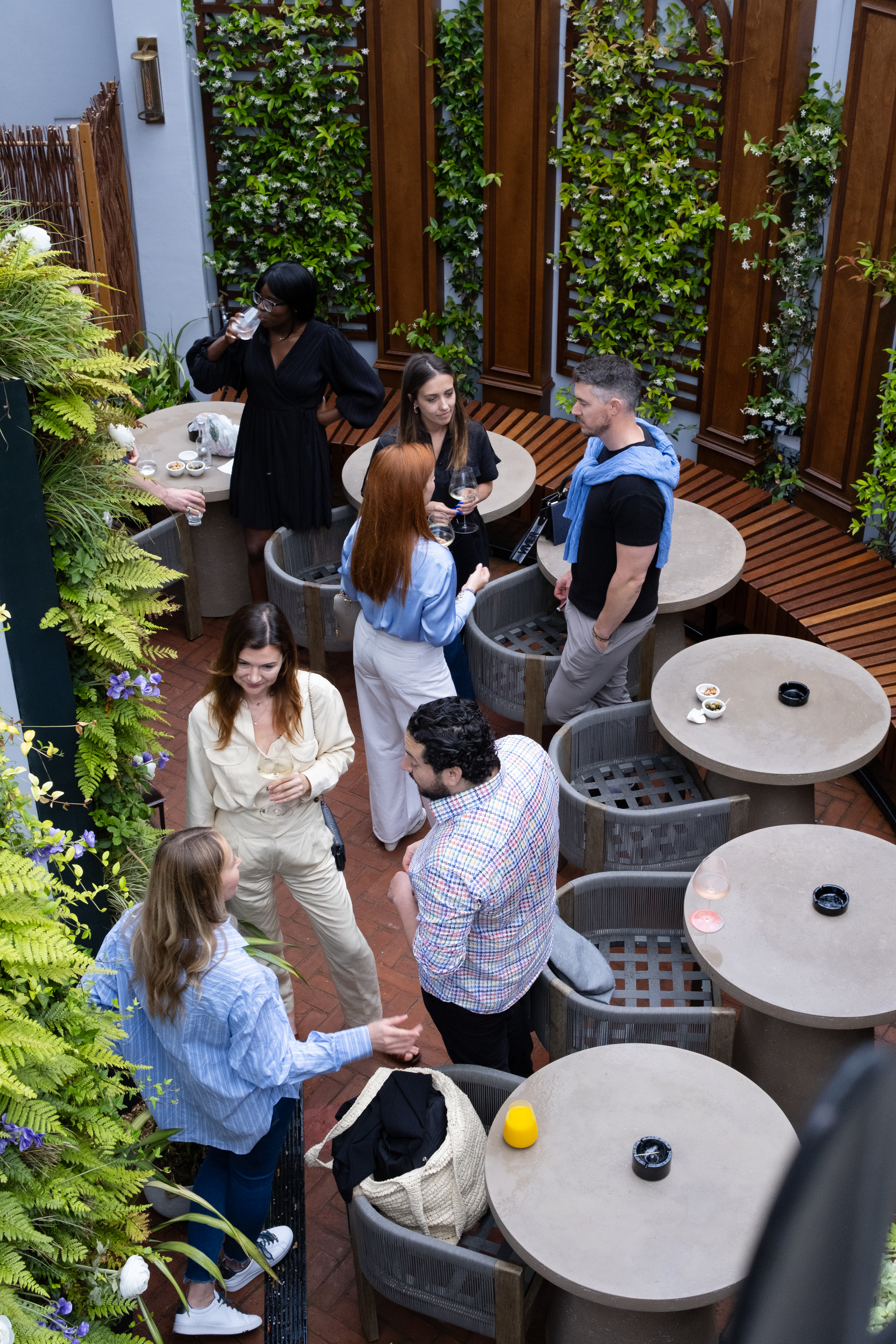 Outdoor networking event at Chesham Hotel Belgravia with engaging attendees and stylish greenery.
