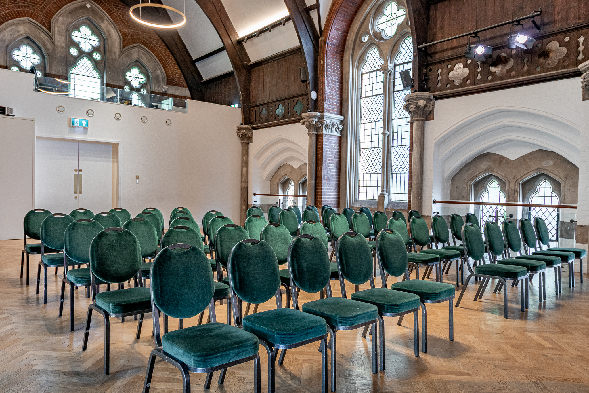 Upper Hall Gothic venue with green seating for boutique conferences and speaker sessions.